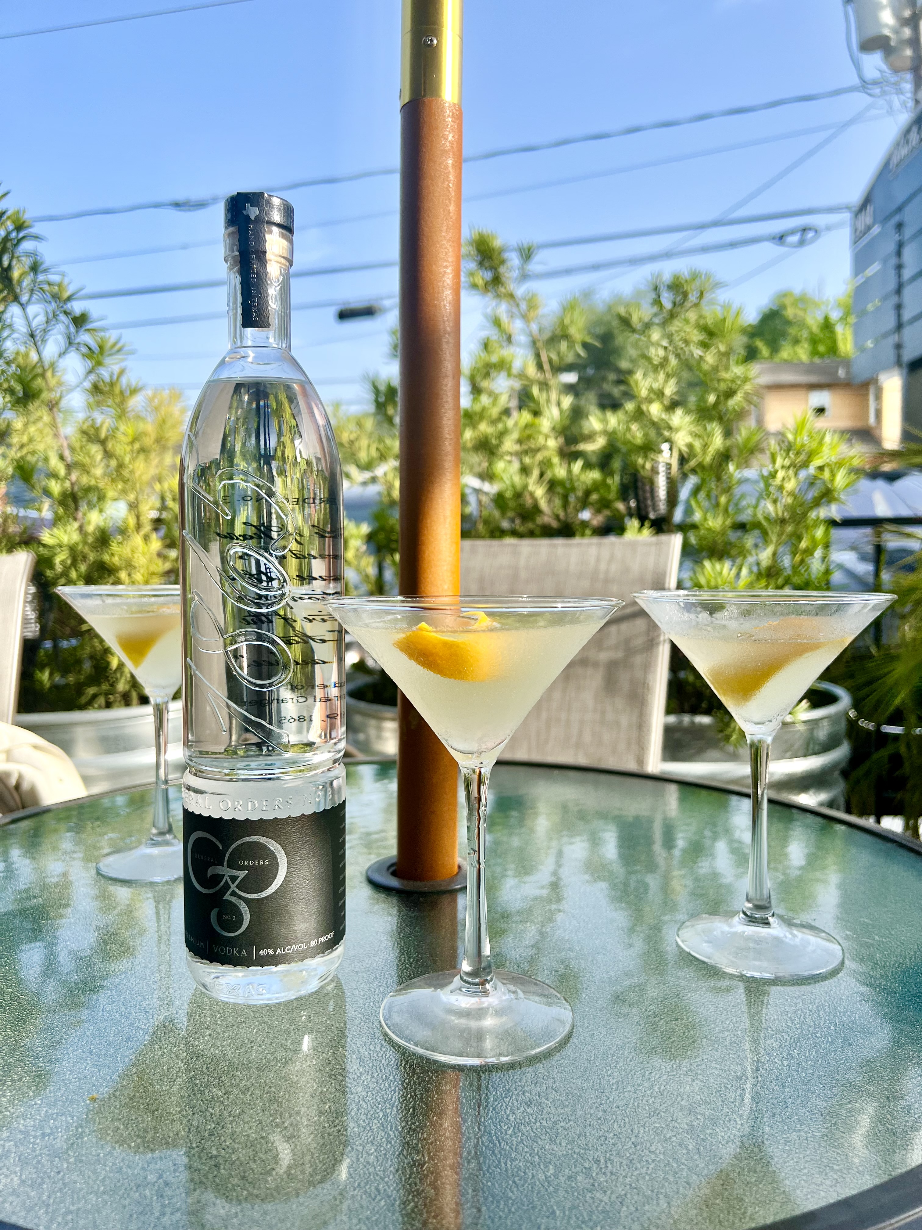 A bottle of General Orders No. 3 vodka with three lemon drop martinis.