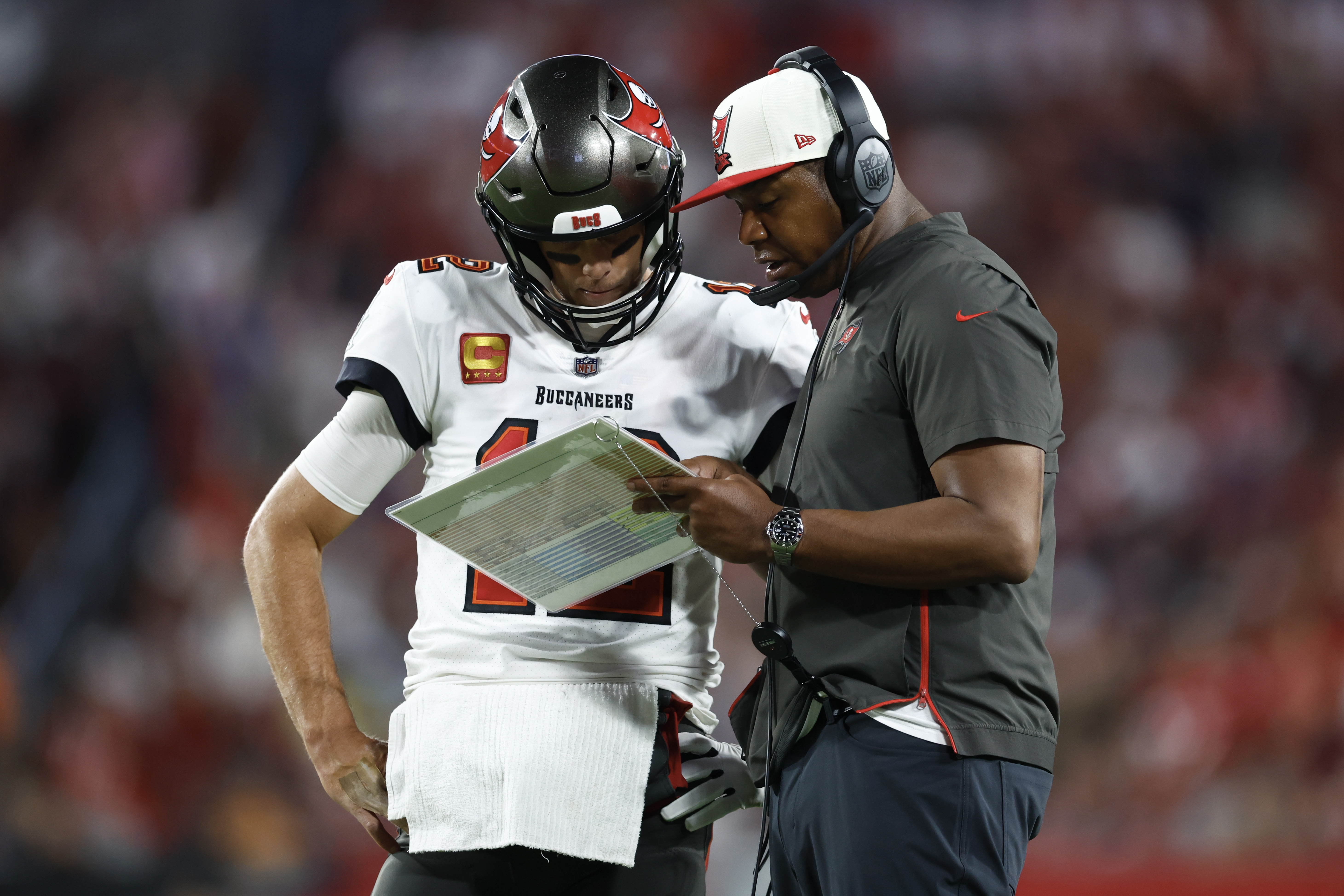 Tom Brady #12 of the Tampa Bay Buccaneers talks with offensive coordinator Byron Leftwich against the Kansas City Chiefs during the third quarter at Raymond James Stadium on October 02, 2022 in Tampa, Florida.