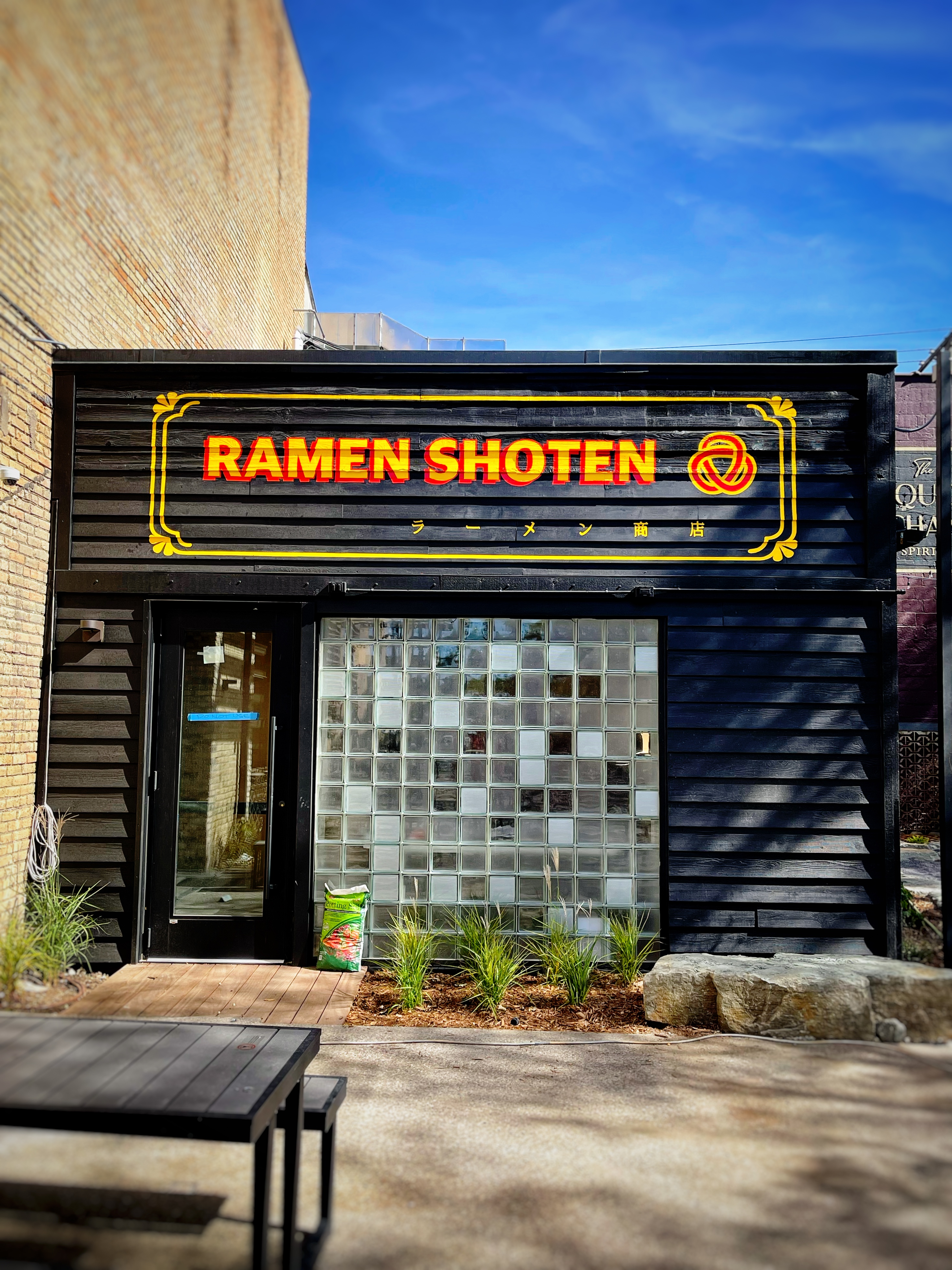 A black building with the words Ramen Shoten in Yellow and red. 