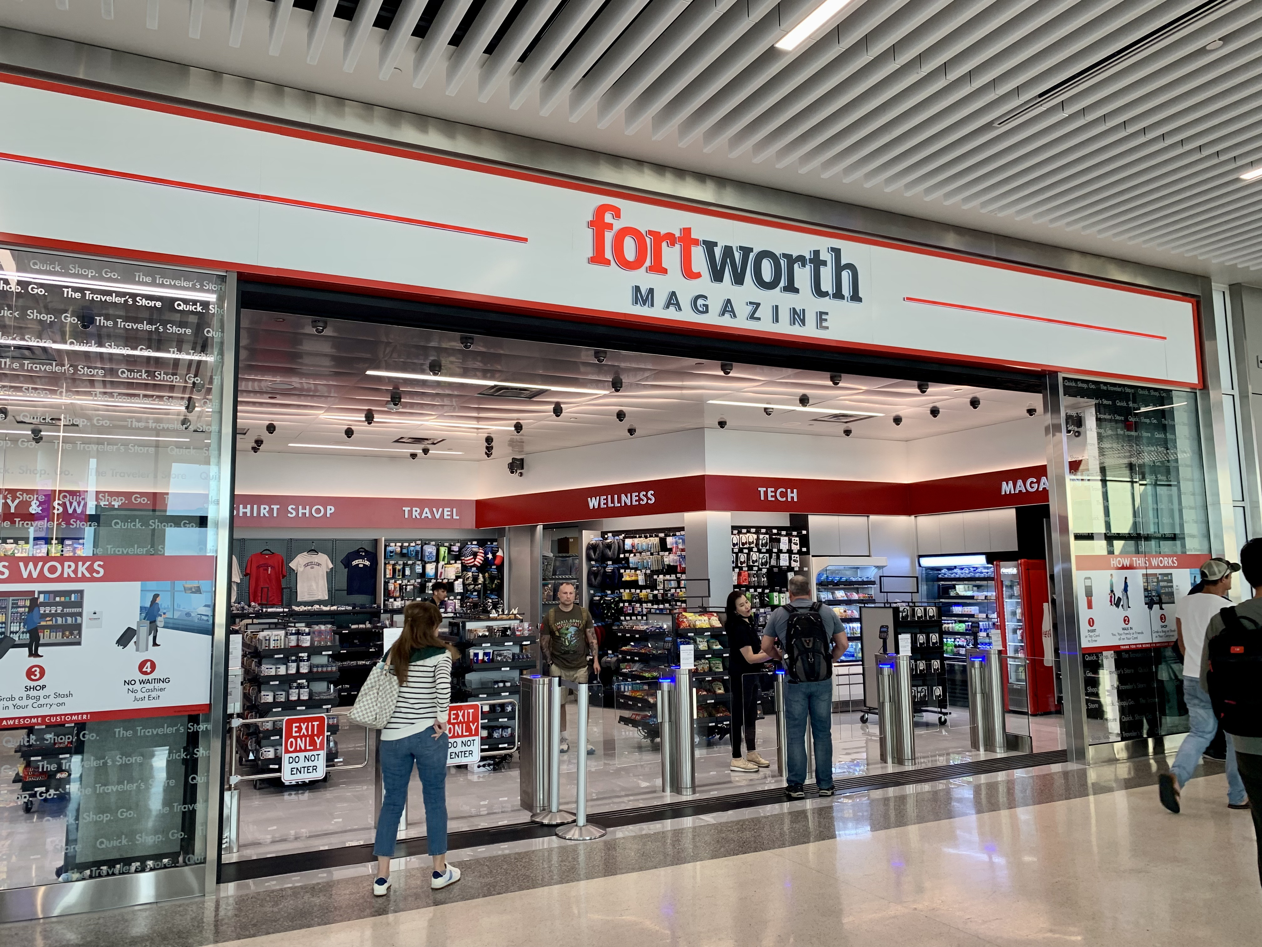 People go in and out of the exterior of an airport magazine and candy shop, with a sign that reads: “Fort Worth Magazine,”