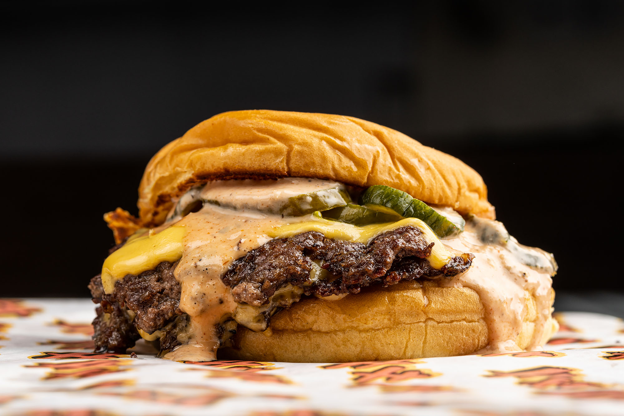 A cheeseburger topped with pickles, sauce, and caramelized onions from Heavy Handed.
