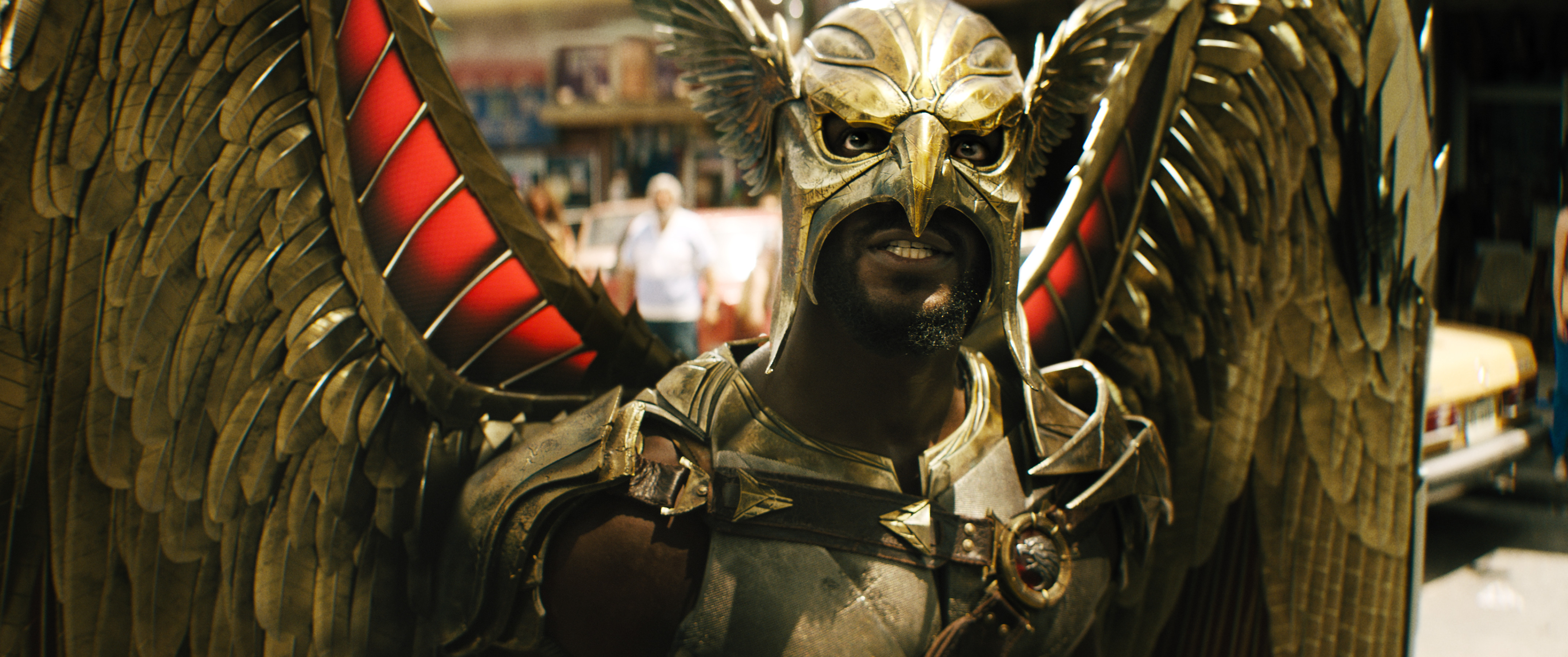 Aldis Hodge as Hawkman in Black Adam. He’s wearing his outfit: An armored chestpiece, a hawk-like helmet that masks the top of his face, and a set of huge metal wings.