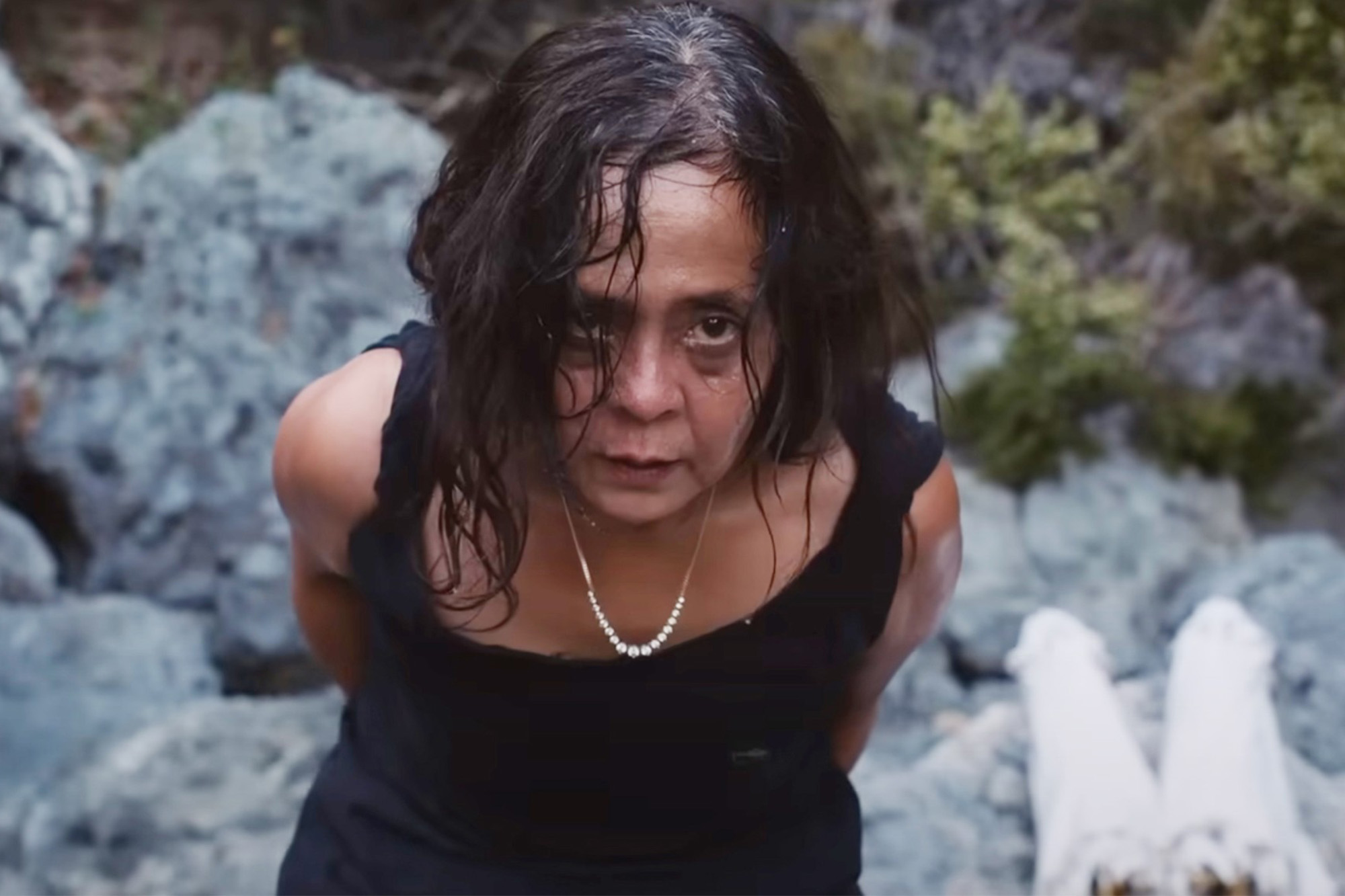 Dolly De Leon looks sweaty and wild-eyed as she hides something behind her back in Triangle of Sadness