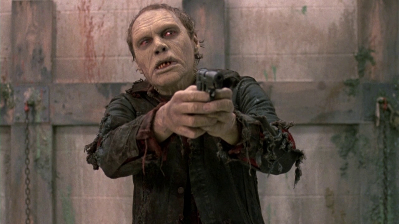 A zombie holds a gun in George Romero’s Day of the Dead.