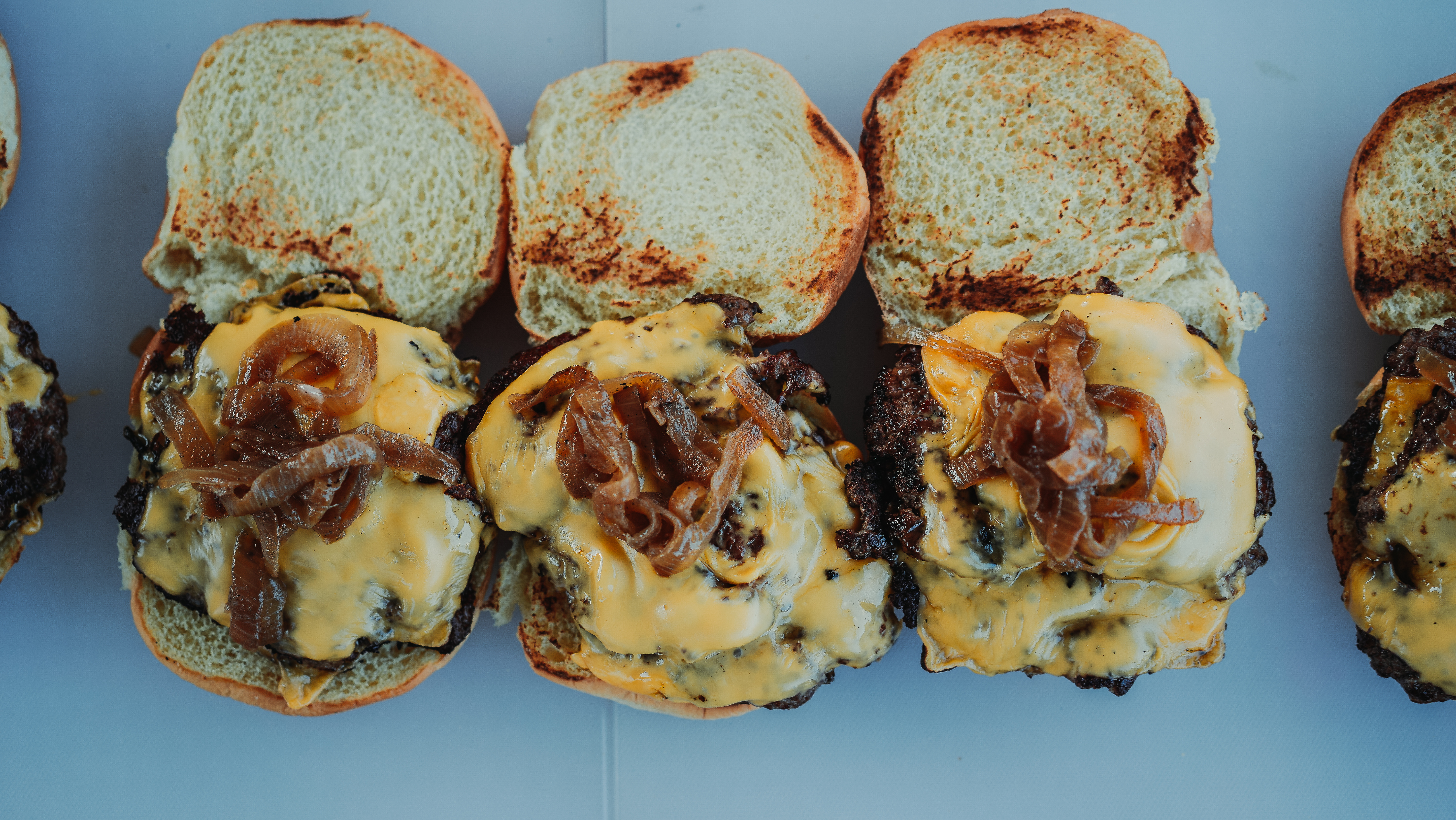 three smash burgers with cheese with caramelized onions from Trill Burger.