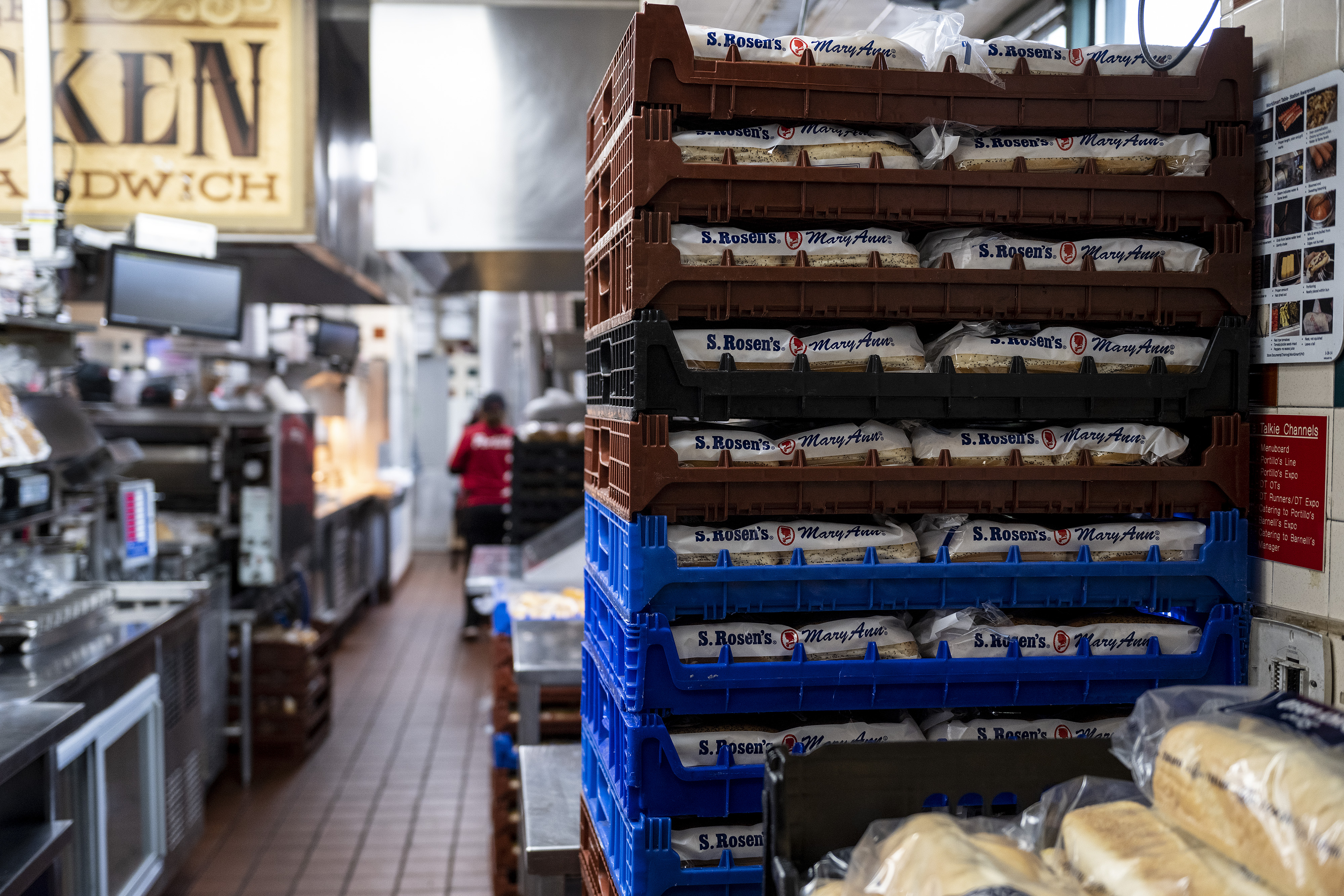 A stack of plastic trays holding bread is seen inside a grocery store.