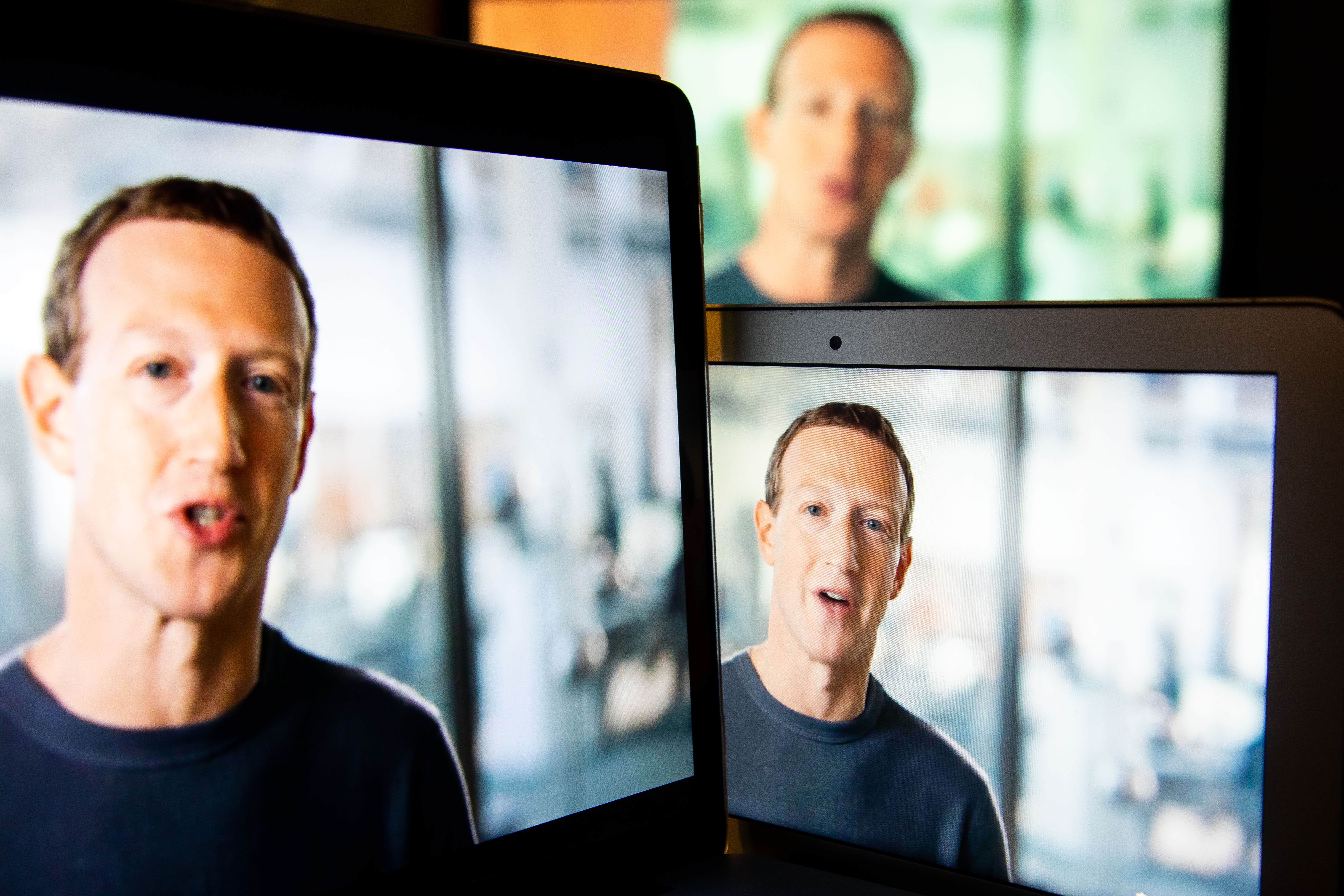 Mark Zuckerberg’s face on three screens.