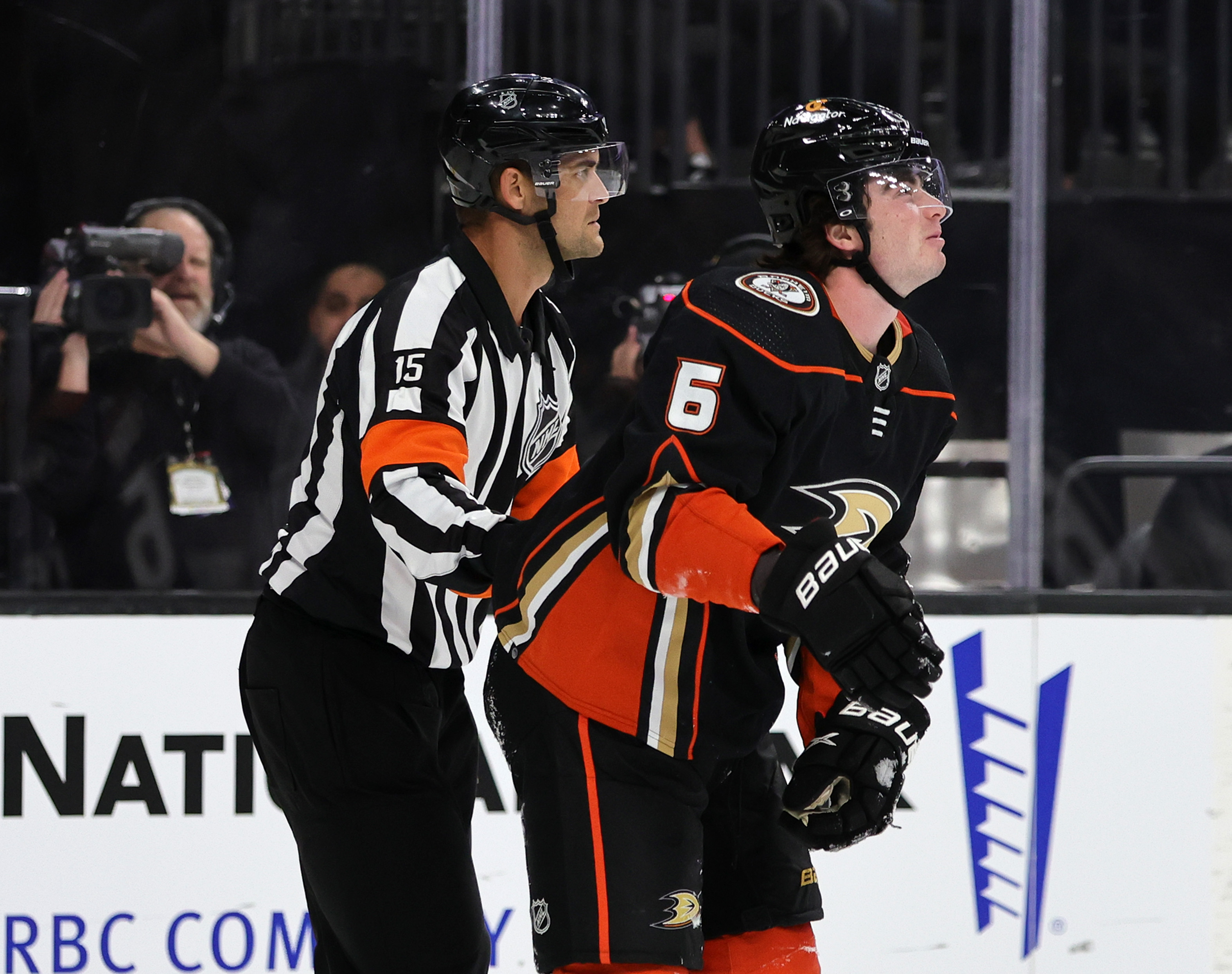 Referee Jean Hebert helps Jamie Drysdale #6 of the Anaheim Ducks off the ice after he suffered an upper body injury in the second period of a game against the Vegas Golden Knights at T-Mobile Arena on October 28, 2022 in Las Vegas, Nevada. The Golden Knights defeated the Ducks 4-0.