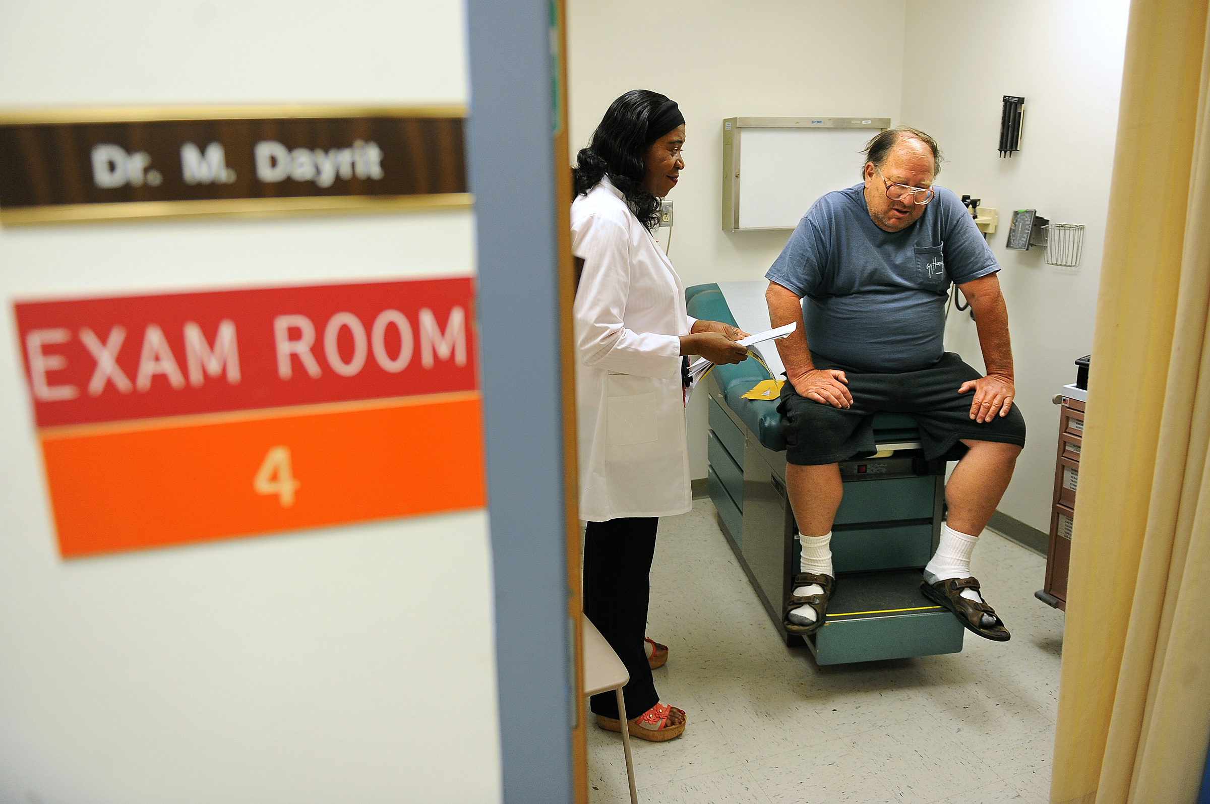 A patient talks with a physician in an examination room during a consultation.