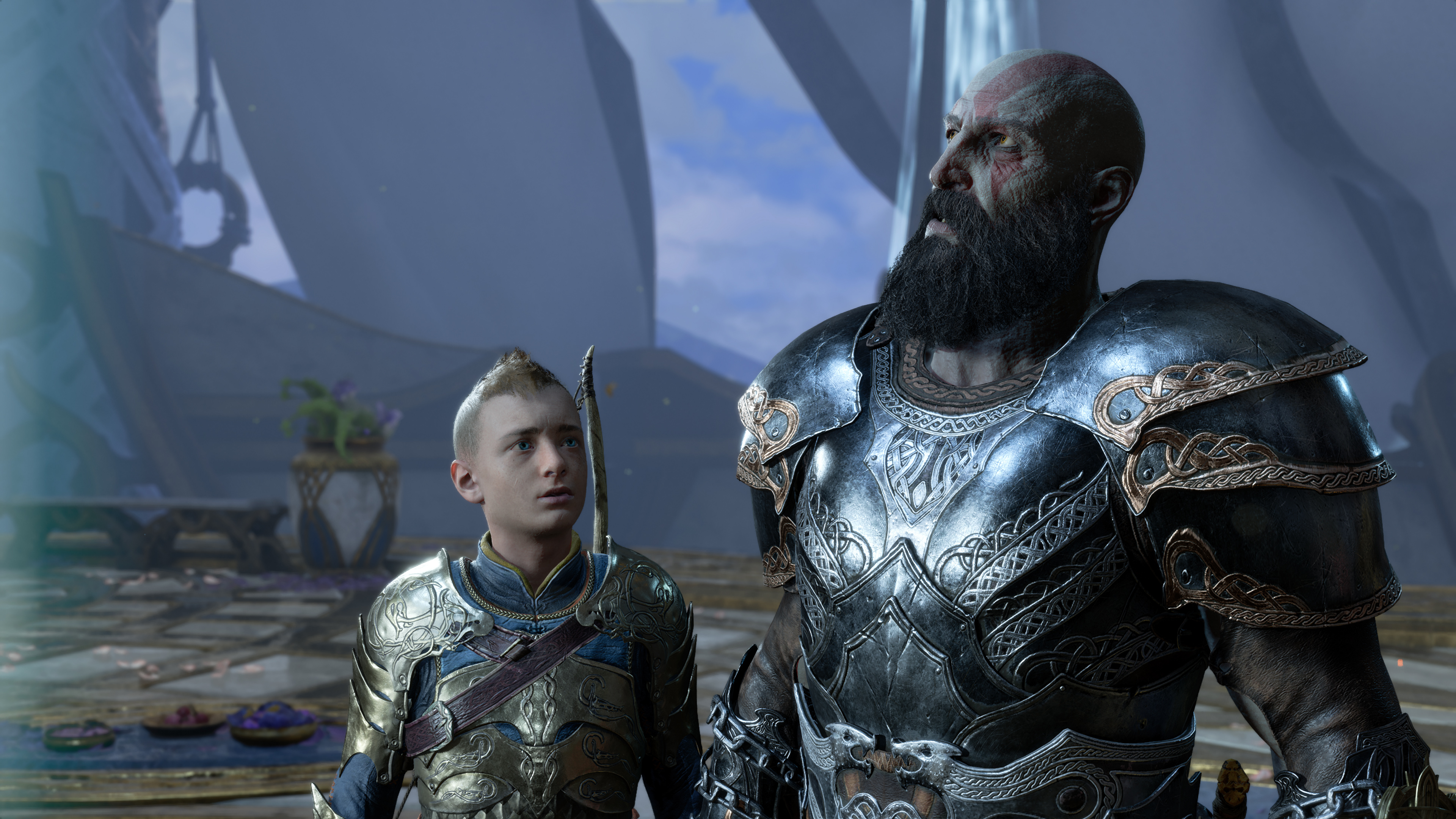 Atreus looking up at Kratos, who is looking upward off screen, in God of War Ragnarök, with both characters wearing shiny armor