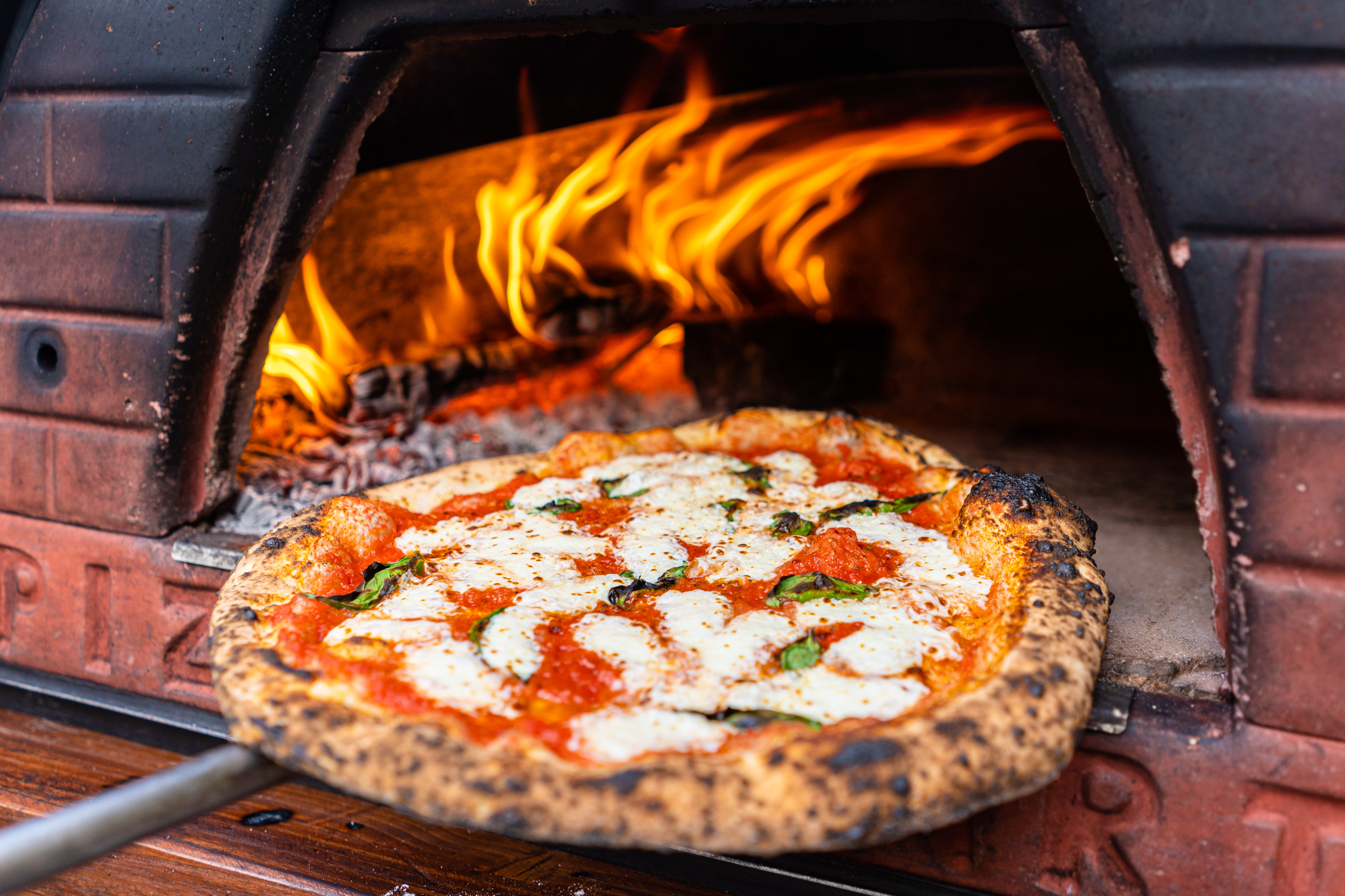 A Margherita Pizza in a pizza oven.