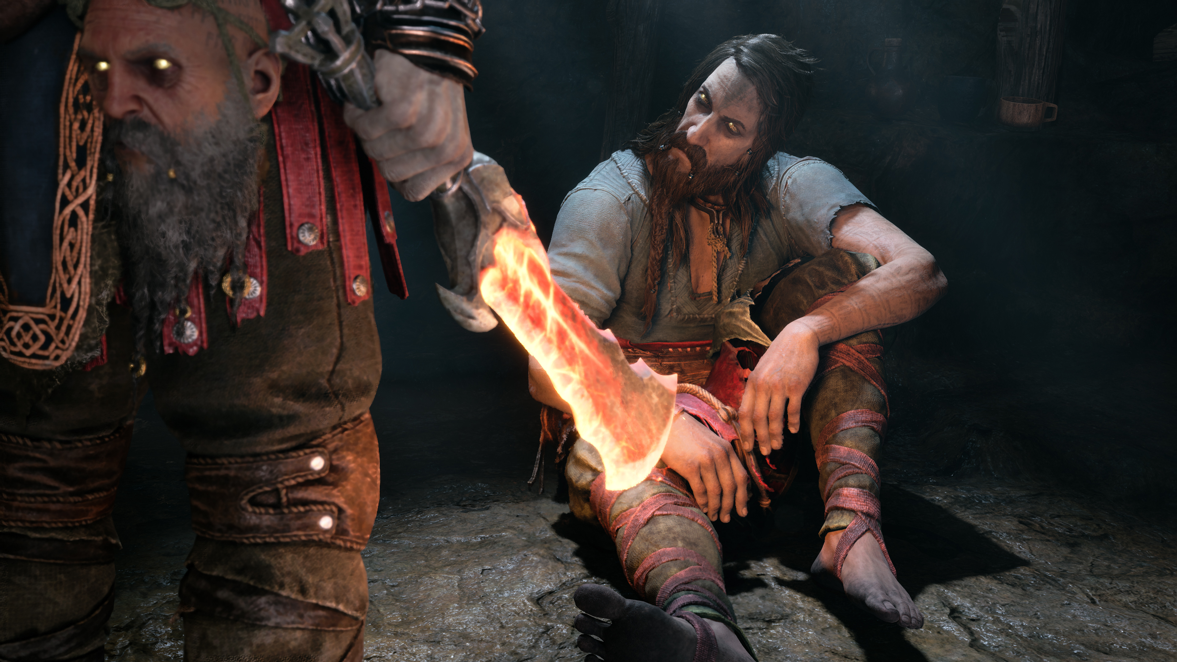 Kratos holding one of his Blades of Chaos, which is glowing red with heat, in front of Tyr sitting on the floor