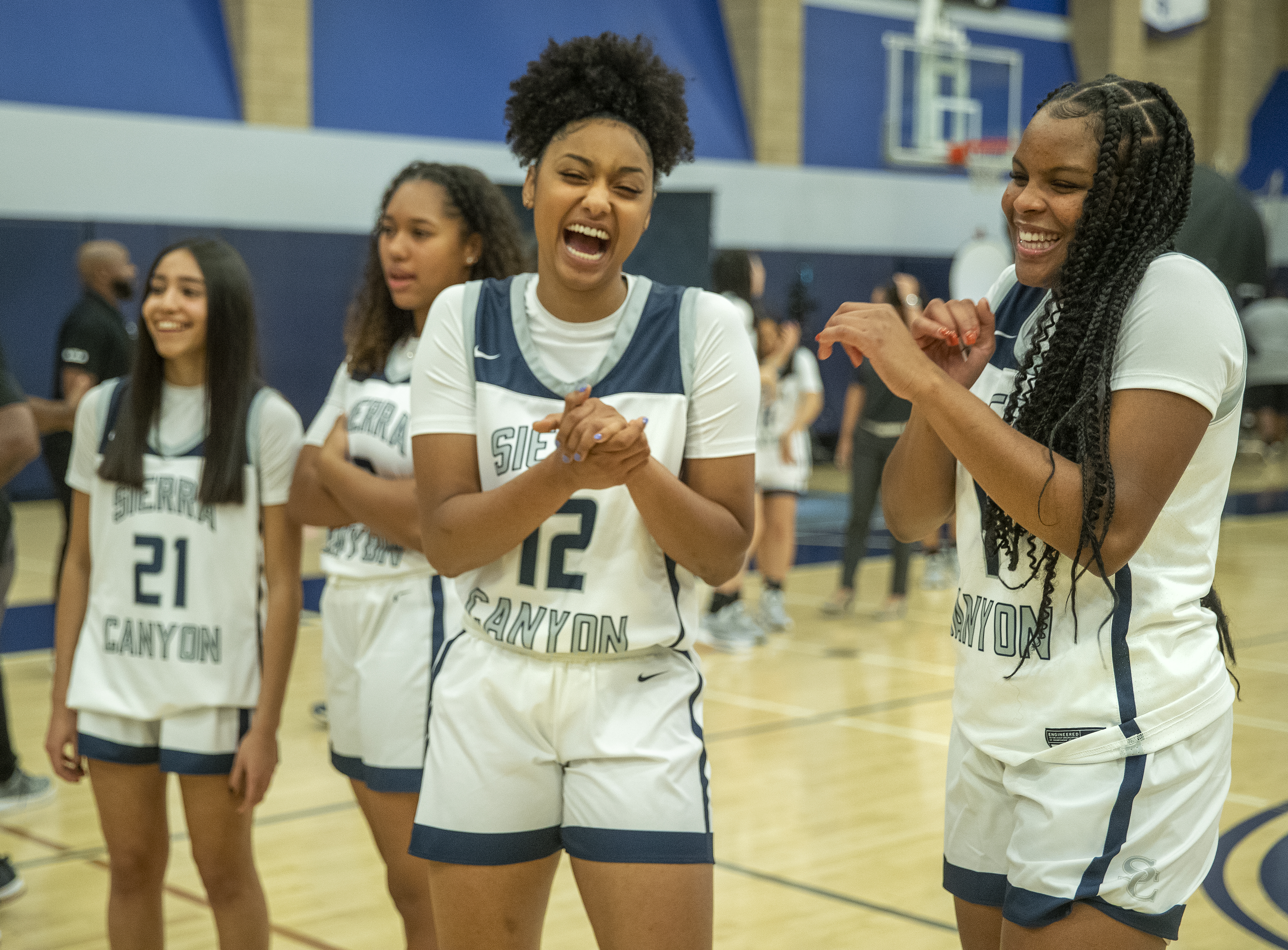 Juju Watkins, foreground, left and Mac Randolph, right, members of the Sierra Canyon girls basketball team, share a light moment together during media day inside the schools gymnasium.