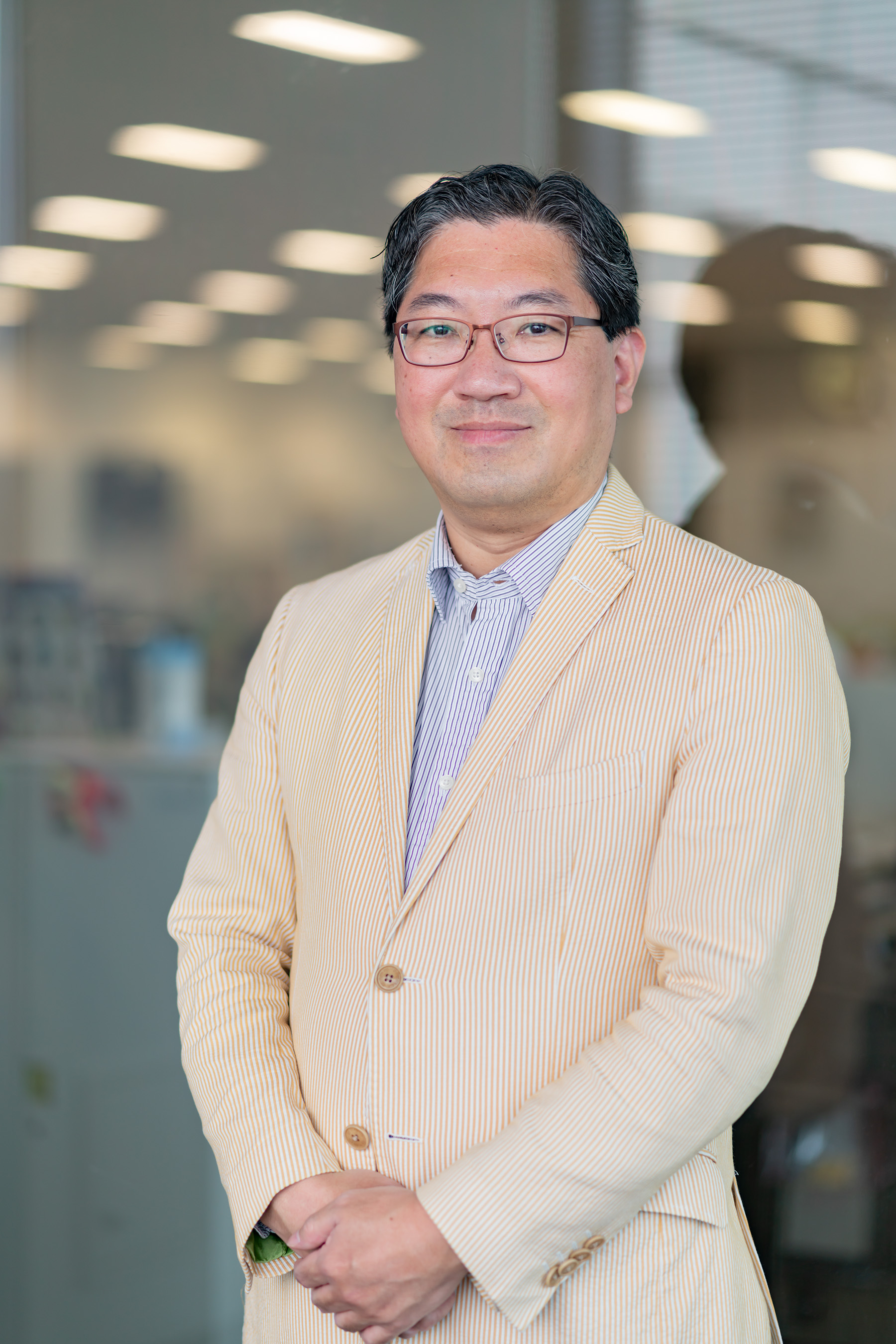 A photo of Yuji Naka standing in an office