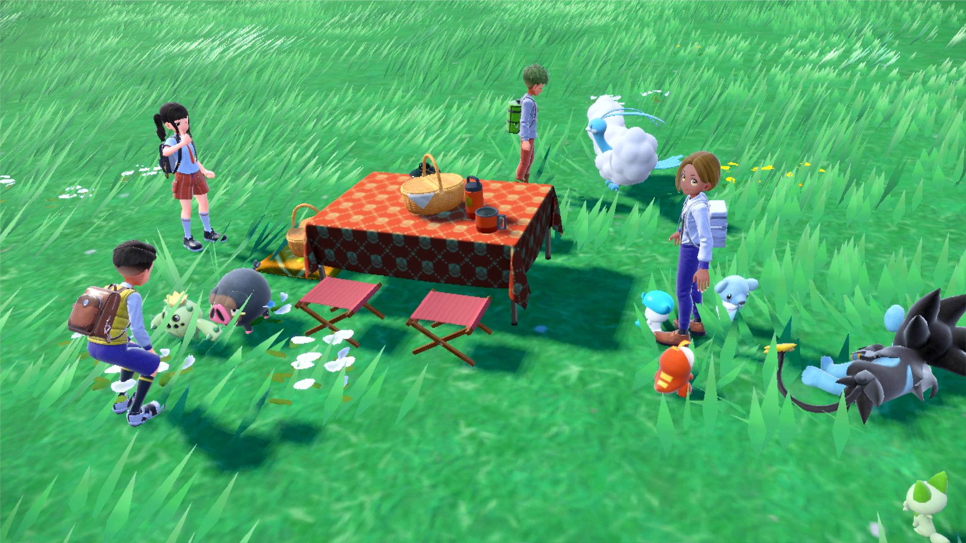 Four Pokémon trainers hanging out around a picnic table with their Pokémon.