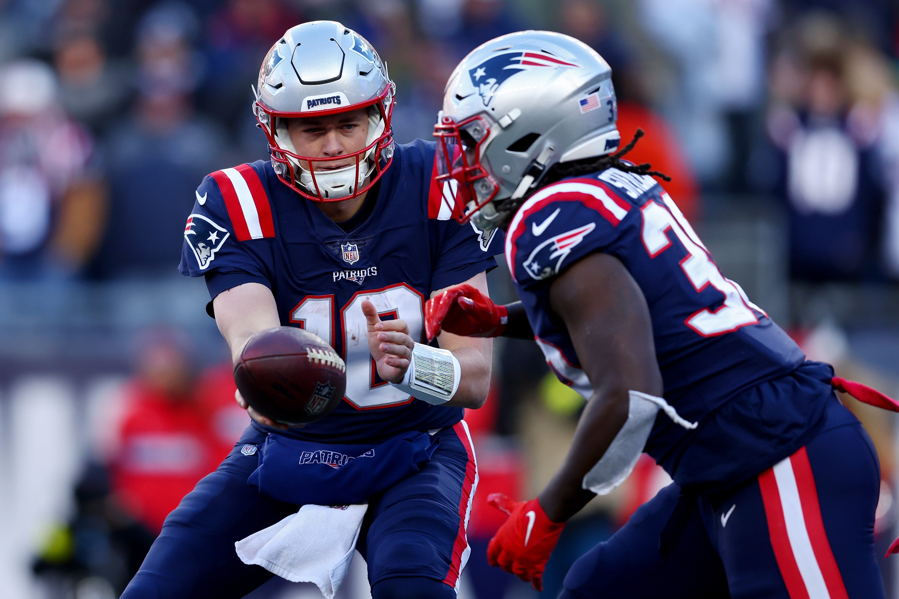 Mac Jones #10 of the New England Patriots hands the ball off to Rhamondre Stevenson #38 of the New England Patriots during the second quarter against the New York Jets at Gillette Stadium on November 20, 2022 in Foxborough, Massachusetts.