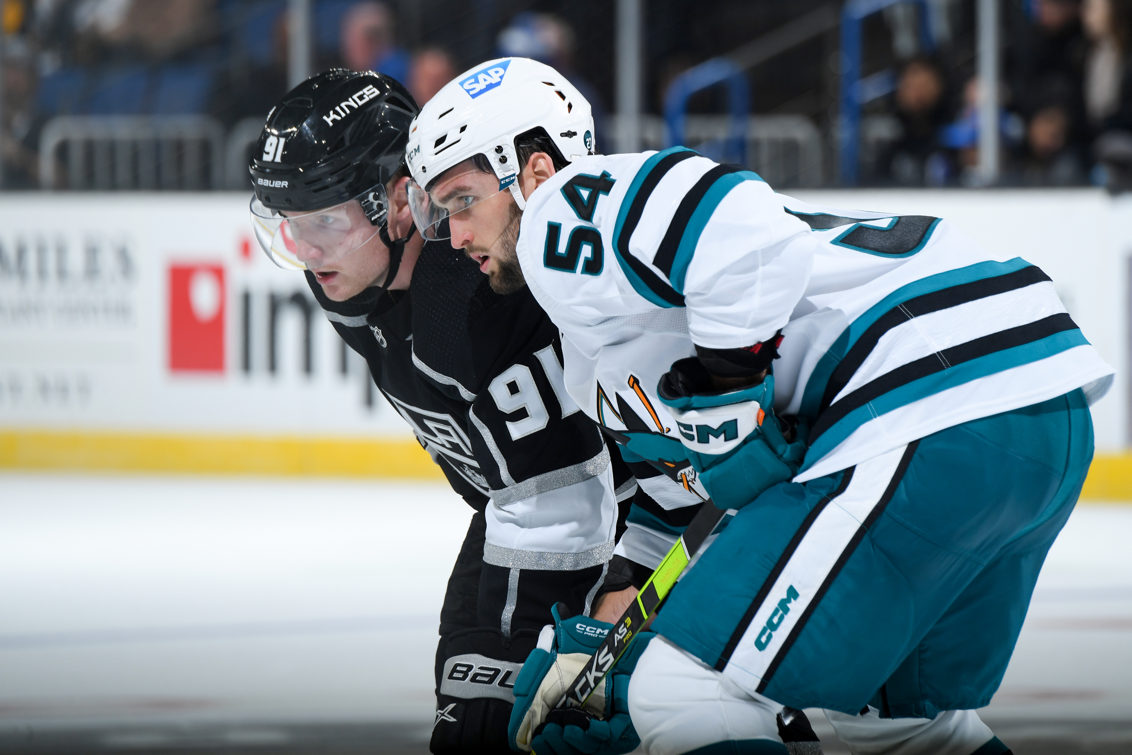 Carl Grundstrom #91 of the Los Angeles Kings and Scott Reedy #54 of the San Jose Sharks get ready for the play during the second period during the preseason game at Toyota Arena on September 28, 2022 in Ontario, California.