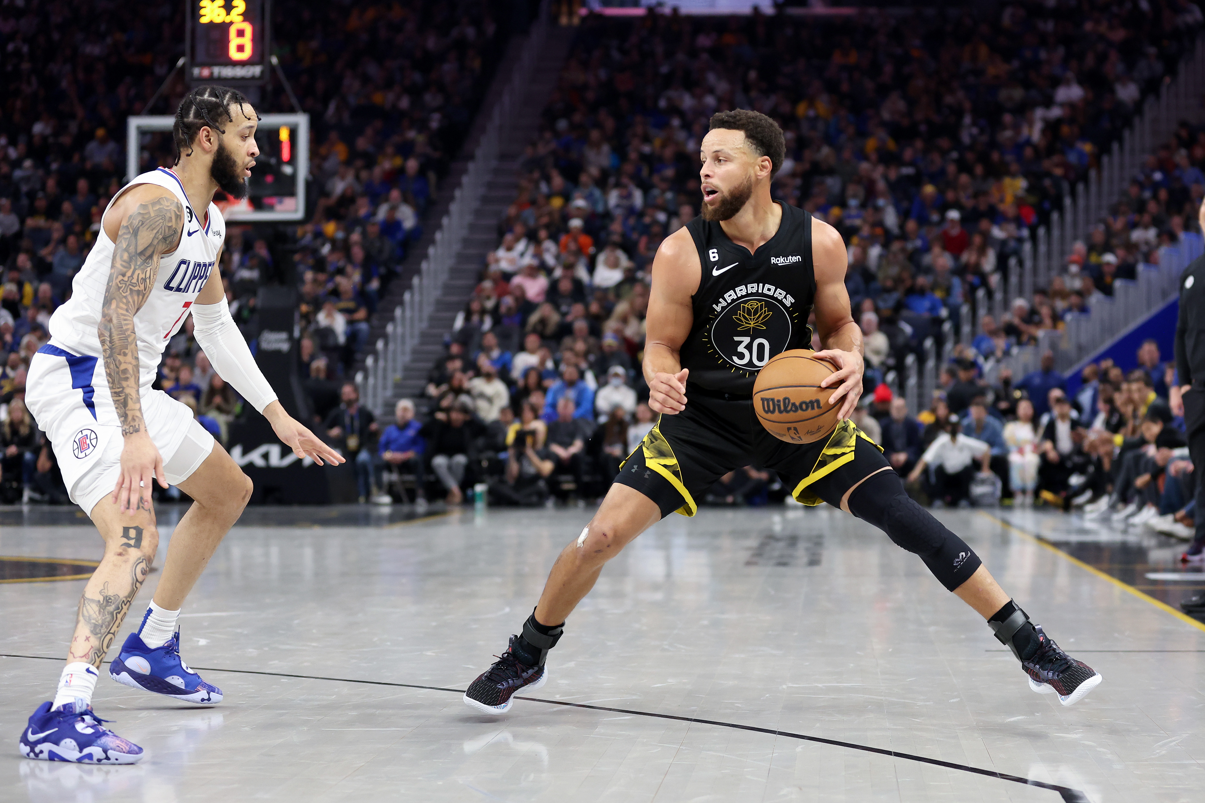 Stephen Curry of the Golden State Warriors is guarded by Amir Coffey of the LA Clippers at Chase Center on November 23, 2022 in San Francisco, California.