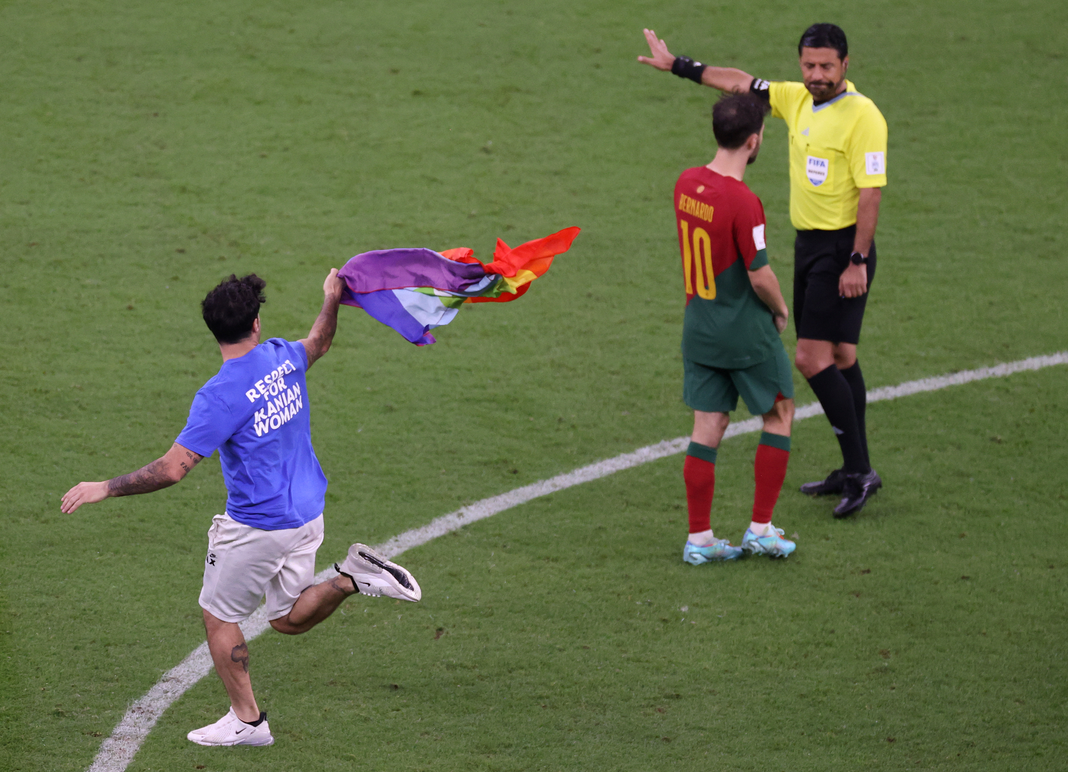 A pitch invader wearing a shirt reading “Respect for Iranian woman” holds rainbow flag during the FIFA World Cup Qatar 2022 Group H match between Portugal and Uruguay at Lusail Stadium on November 28, 2022 in Lusail City, Qatar.