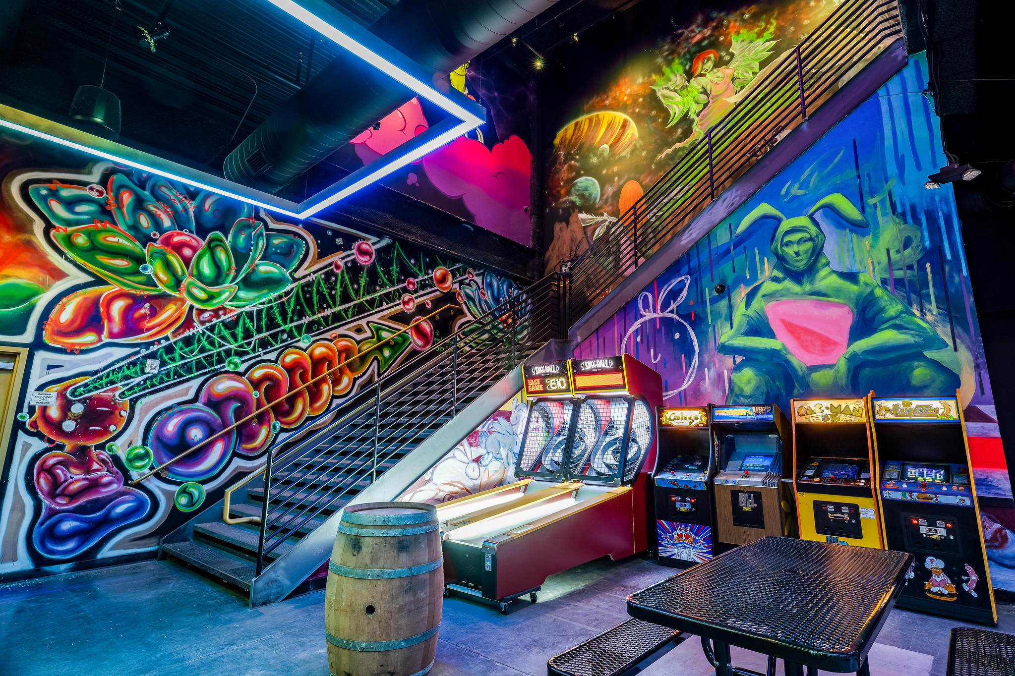 A bar with graffiti art and gaming machines.