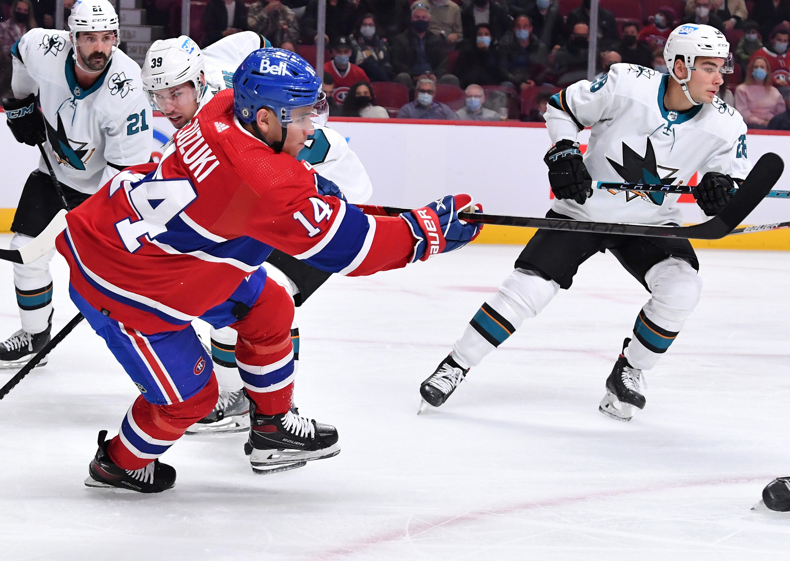 Nick Suzuki #14 of the Montreal Canadiens passes the puck against the San Jose Sharks in the NHL game at the Bell Centre on October 19, 2021 in Montreal, Quebec, Canada.