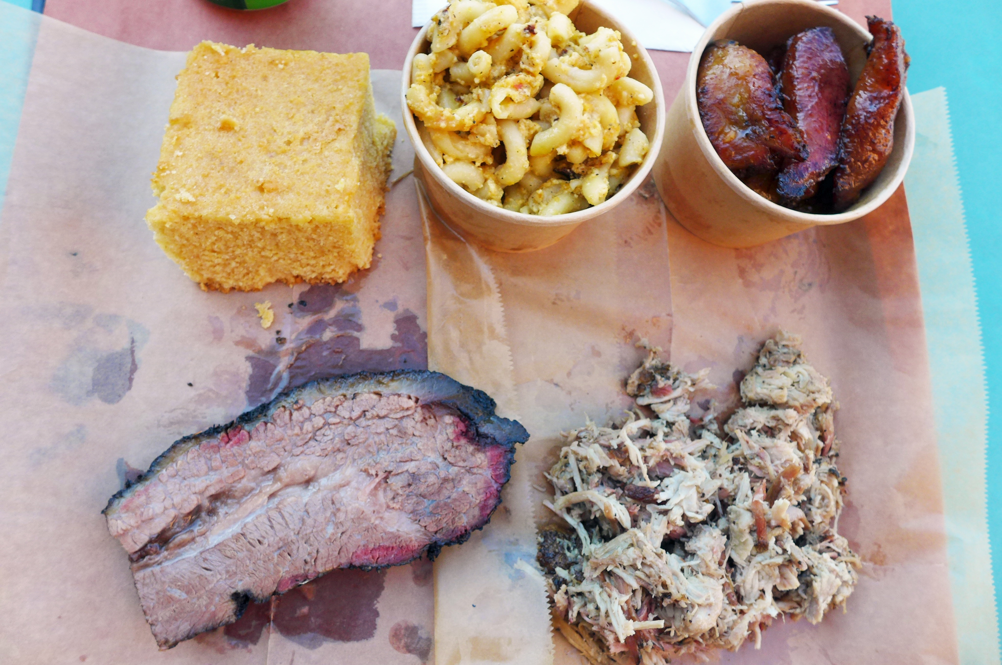 Two meats and three sides on a paper lined tray.