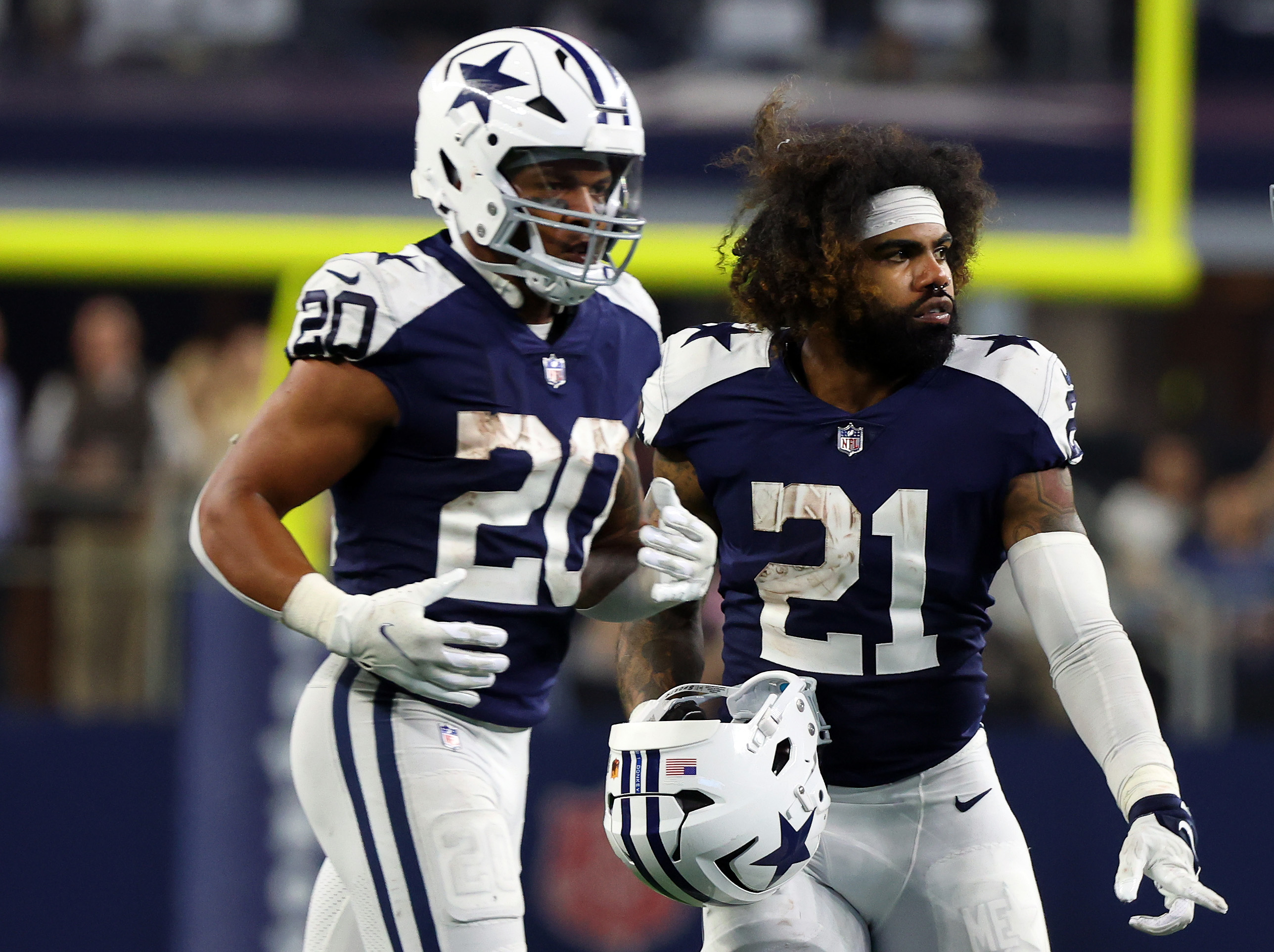 Tony Pollard #20 and Ezekiel Elliott #21 of the Dallas Cowboys stand on the field during the game against the New York Giants at AT&amp;T Stadium on November 24, 2022 in Arlington, Texas.