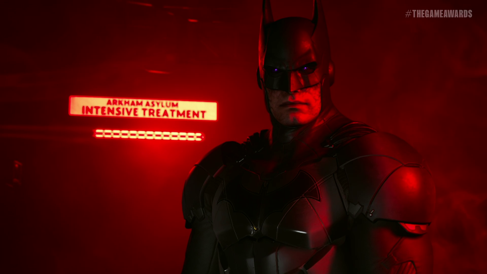 Batman lit by red light, with a sign reading “Arkham Asylum Intensive Treatment” behind him, in Suicide Squad: Kill the Justice League