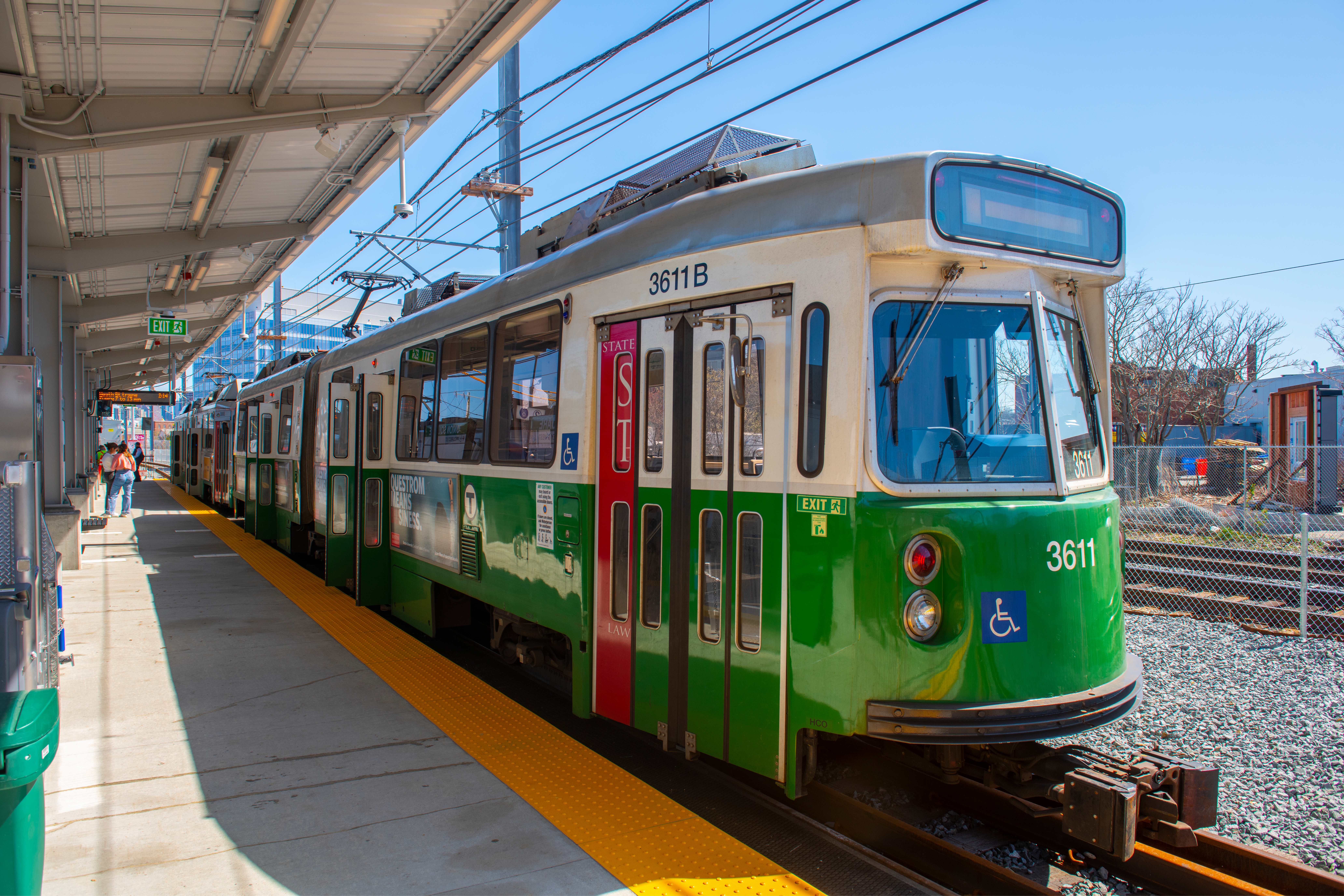 A Green Line subway car pulled up at an aboveground station.
