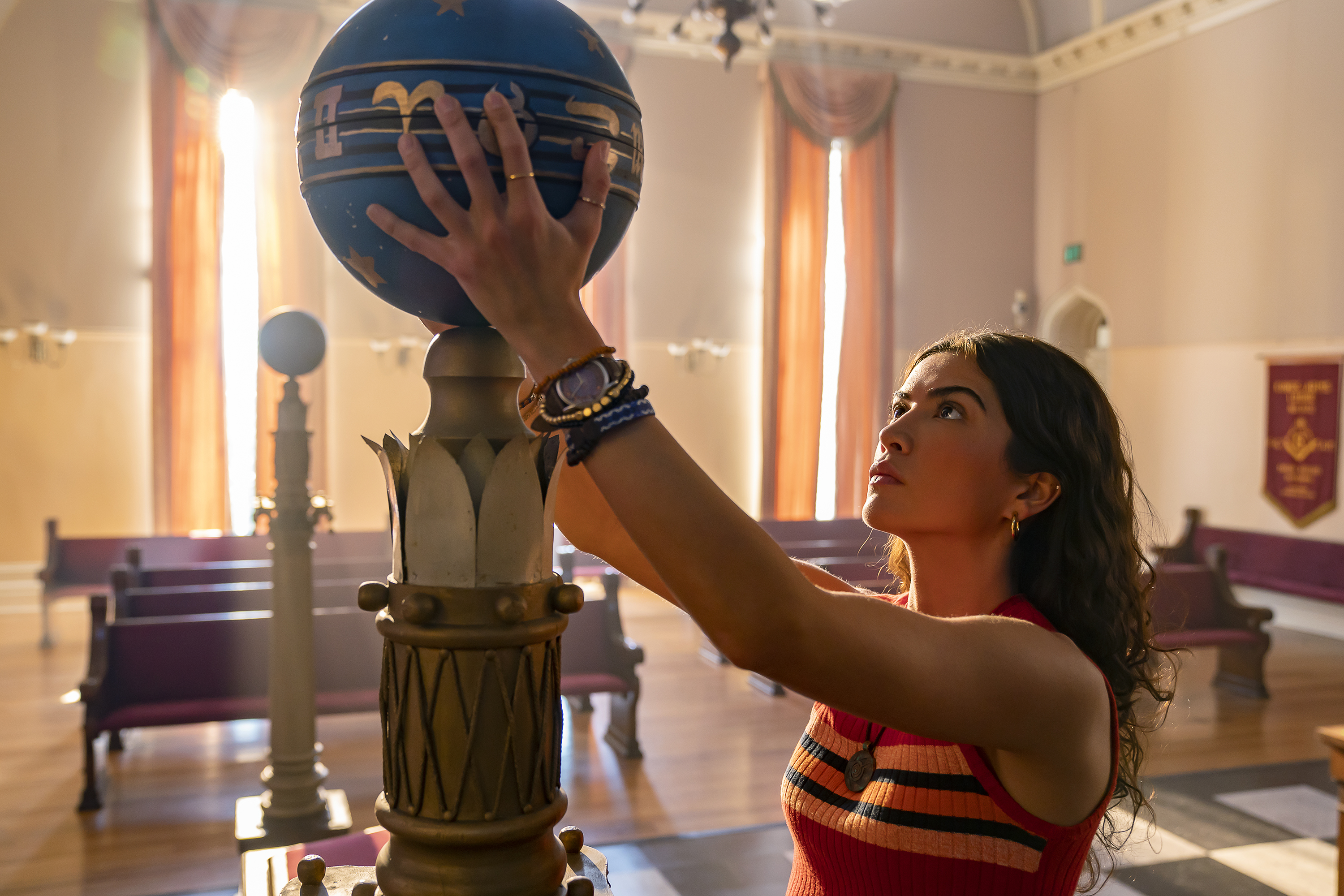 Jess (Lisette Alexis) examining a large, spherical artifact in the Disney Plus National Treasure series