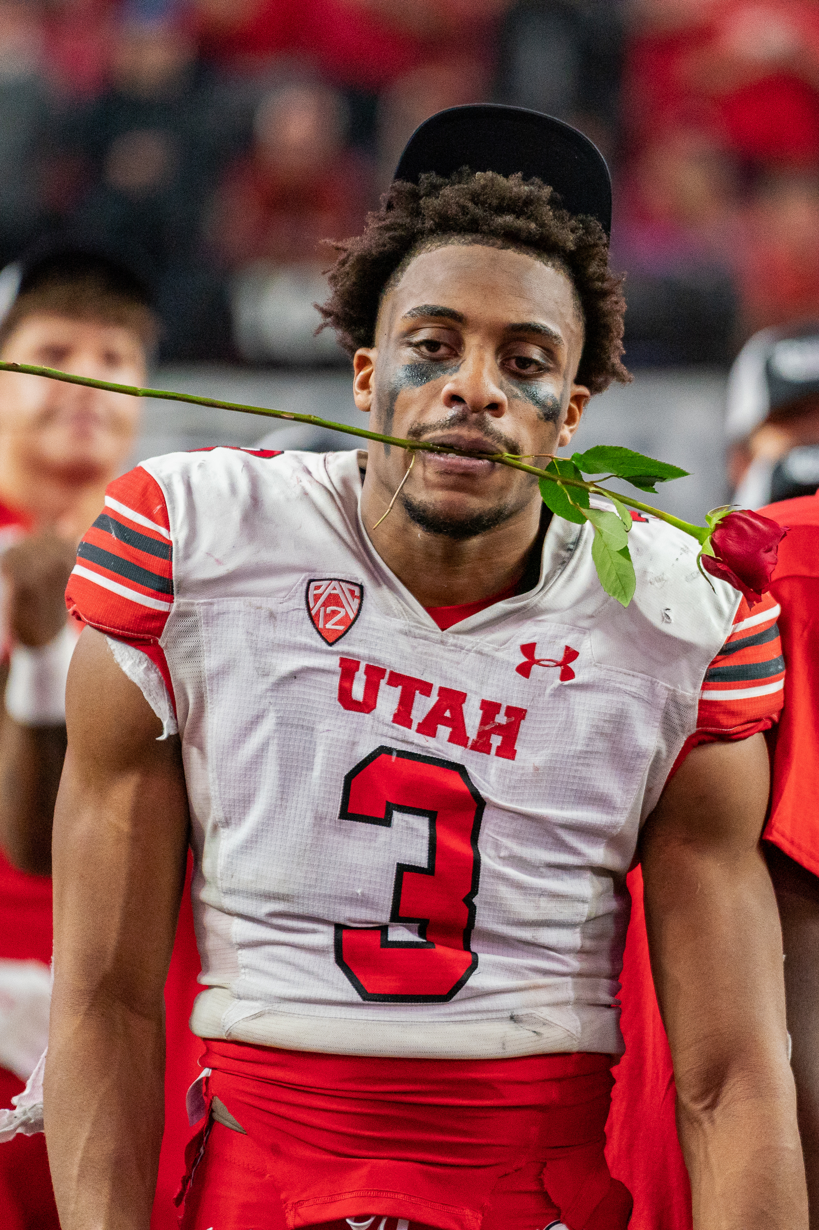 Utah player holding a rose with his mouth after winning the Pac-12 Championship Game.