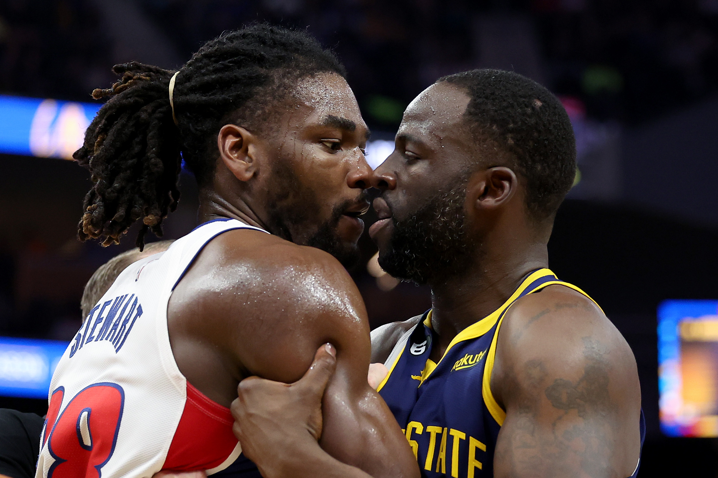 Draymond Green and Isaiah Stewart nose-to-nose while grabbing each other in an altercation