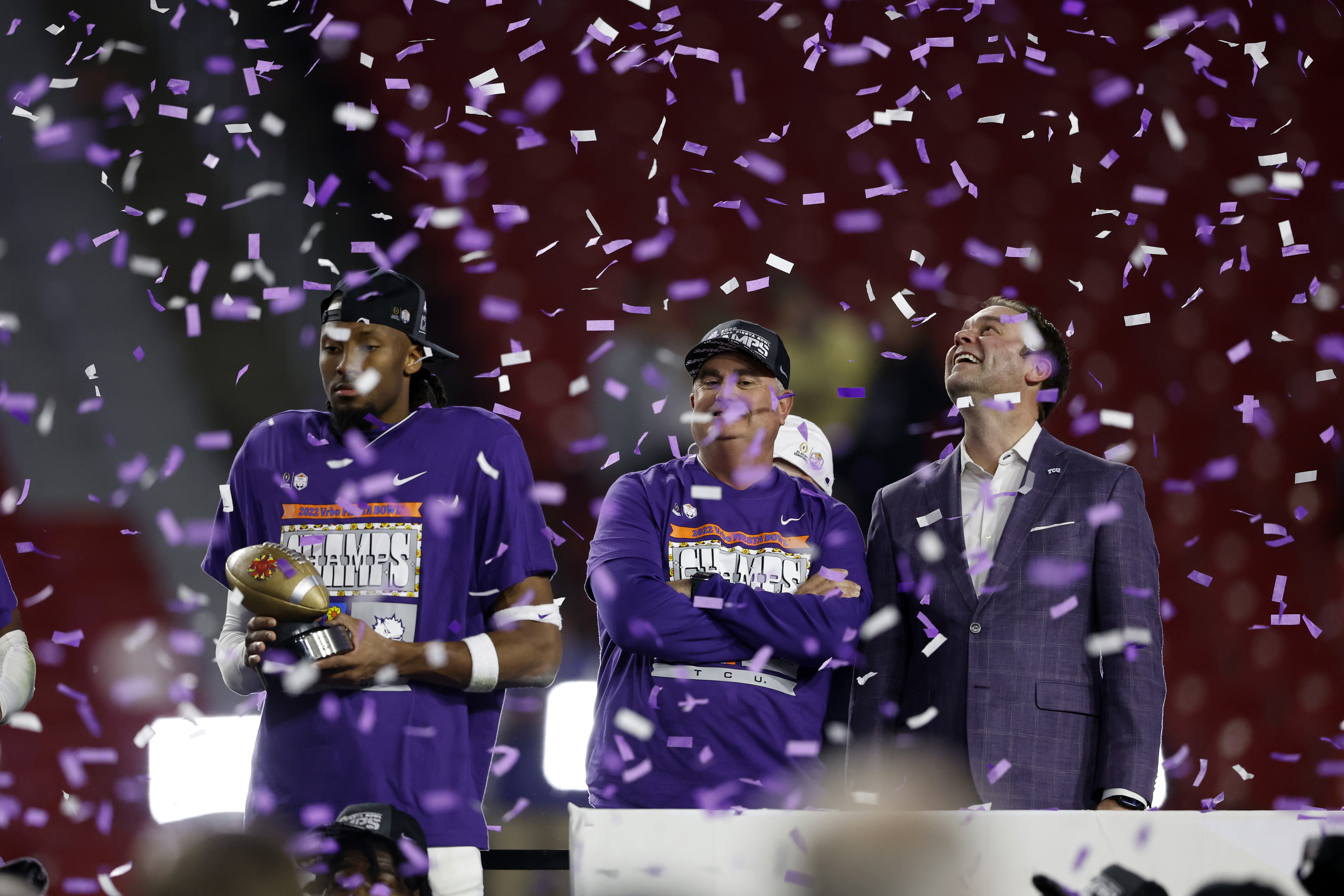 Wide receiver Quentin Johnston, head coach Sonny Dykes and athletic director Jeremiah Donati of the TCU Horned Frogs stand on the podium after defeating the Michigan Wolverines 51-45 during the Vrbo Fiesta Bowl at State Farm Stadium on December 31, 2022 in Glendale, Arizona.