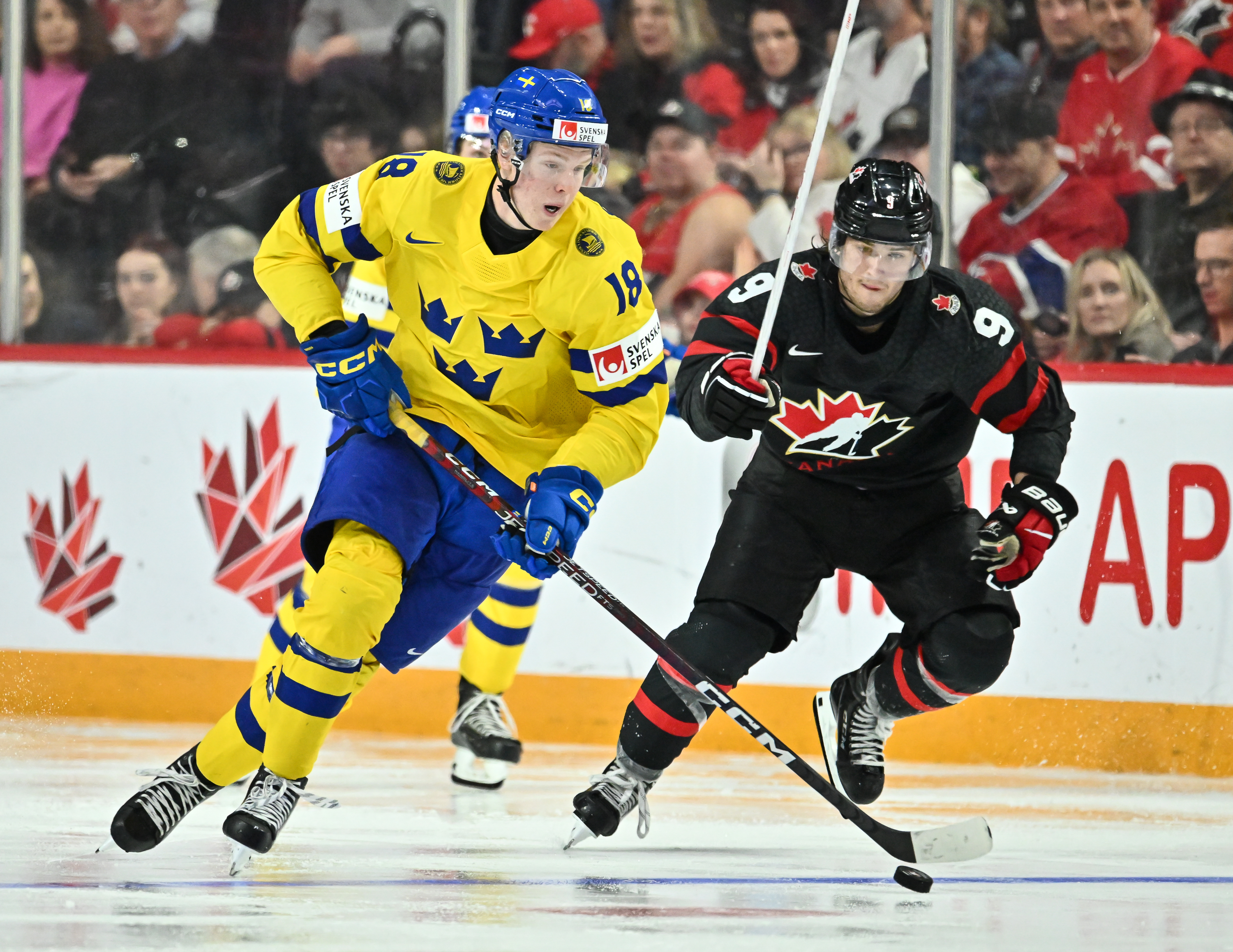 Filip Bystedt #18 of Team Sweden skates the puck against Joshua Roy #9 of Team Canada during the third period in the 2023 IIHF World Junior Championship at Scotiabank Centre on December 31, 2022 in Halifax, Nova Scotia, Canada. Team Canada defeated Team Sweden 5-1.