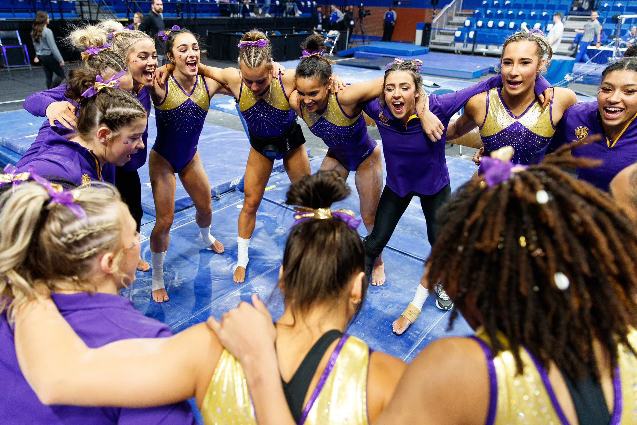 LSU gymnasts stand in a huddle warm-up leotards prior to their meet against Kentucky in Rupp Arena