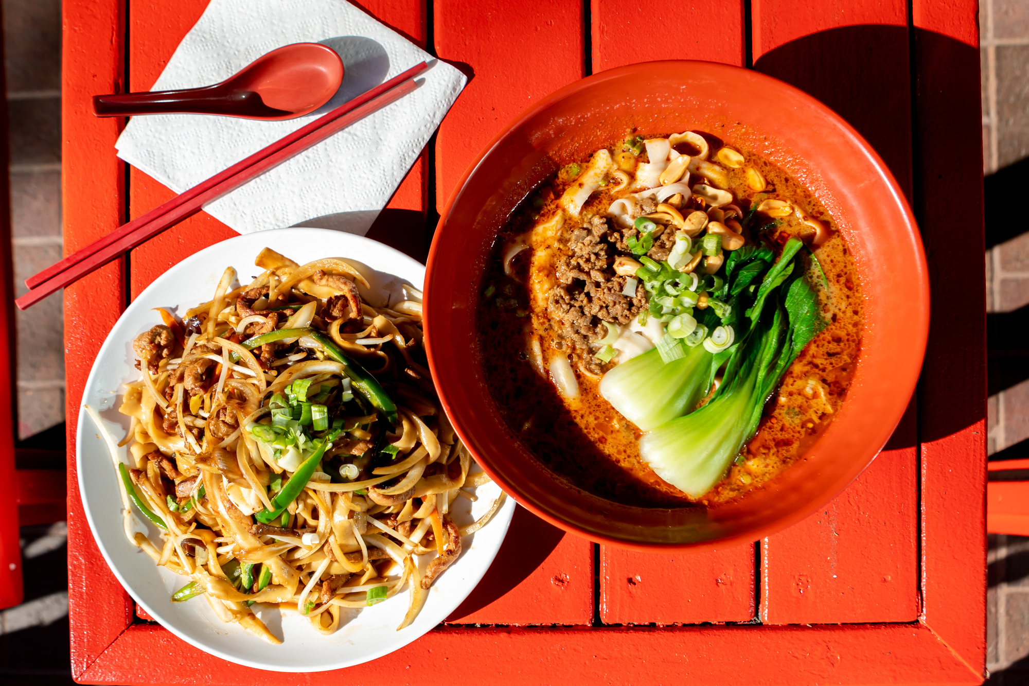 Overhead view of two styles of knife-cut noodles, one dry and the other in a bowl of broth