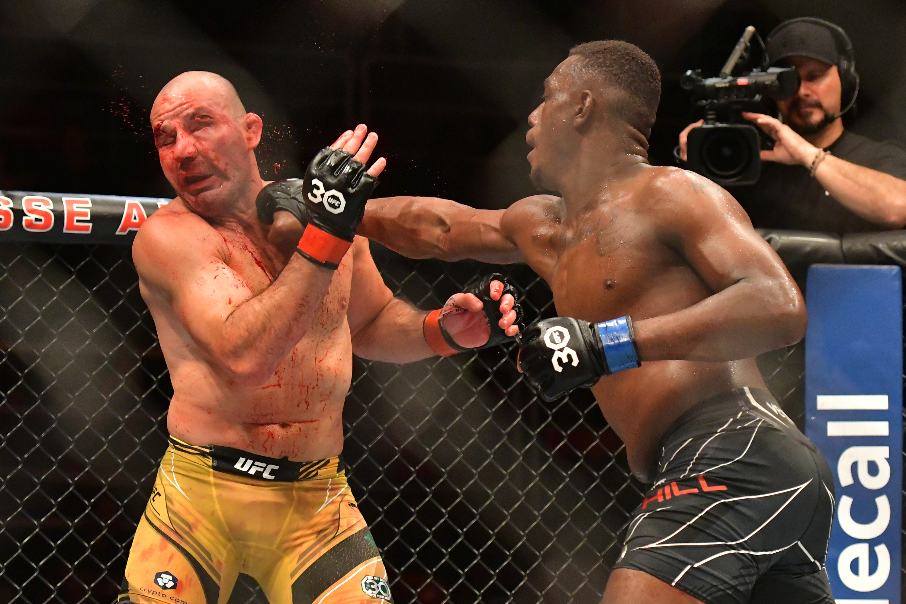 Glover Teixeira eats a right hand from Jamahal Hill in the main event of UFC 283.