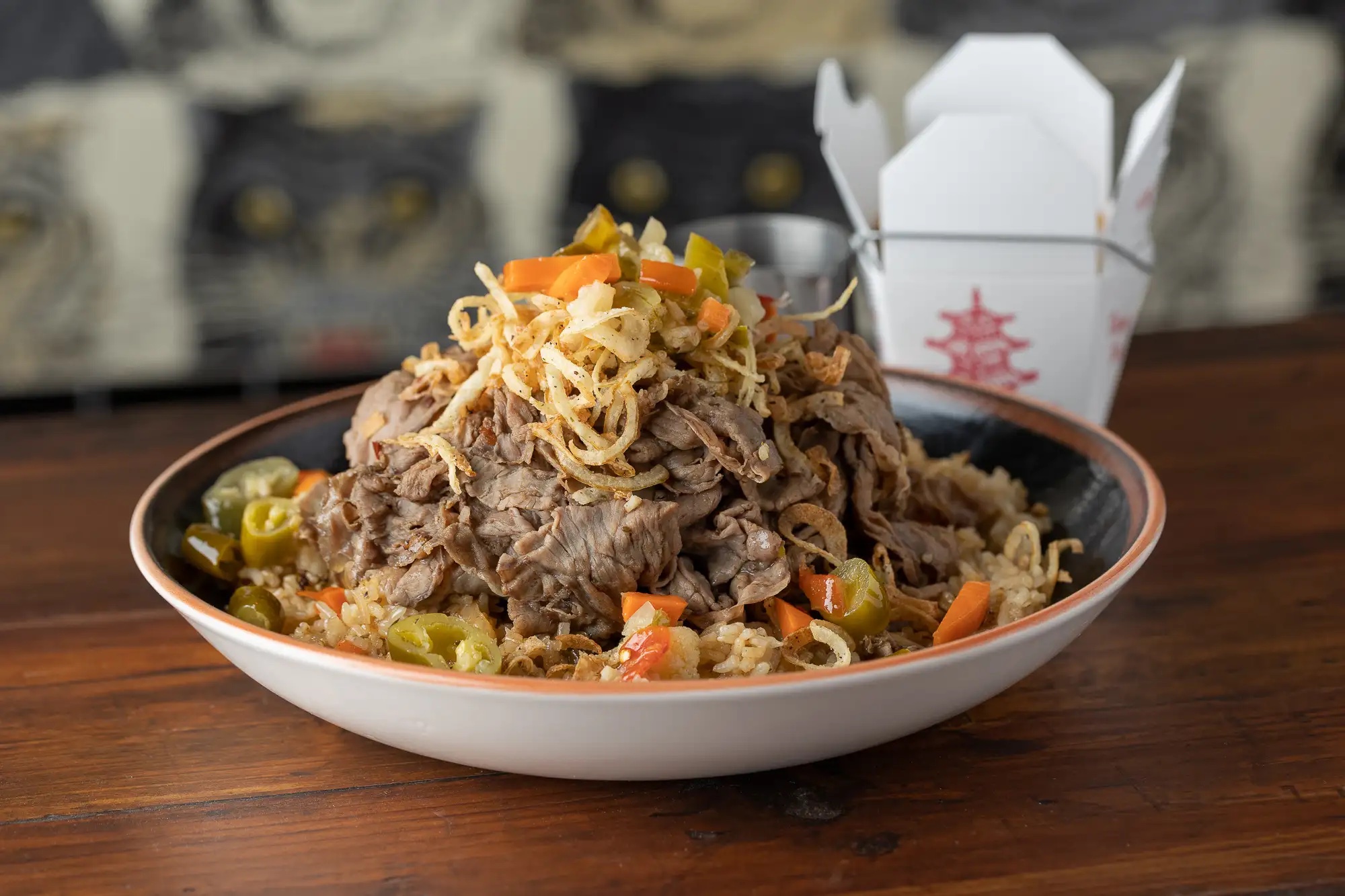 A round white plate holds a large pile of Italian beef fried rice.