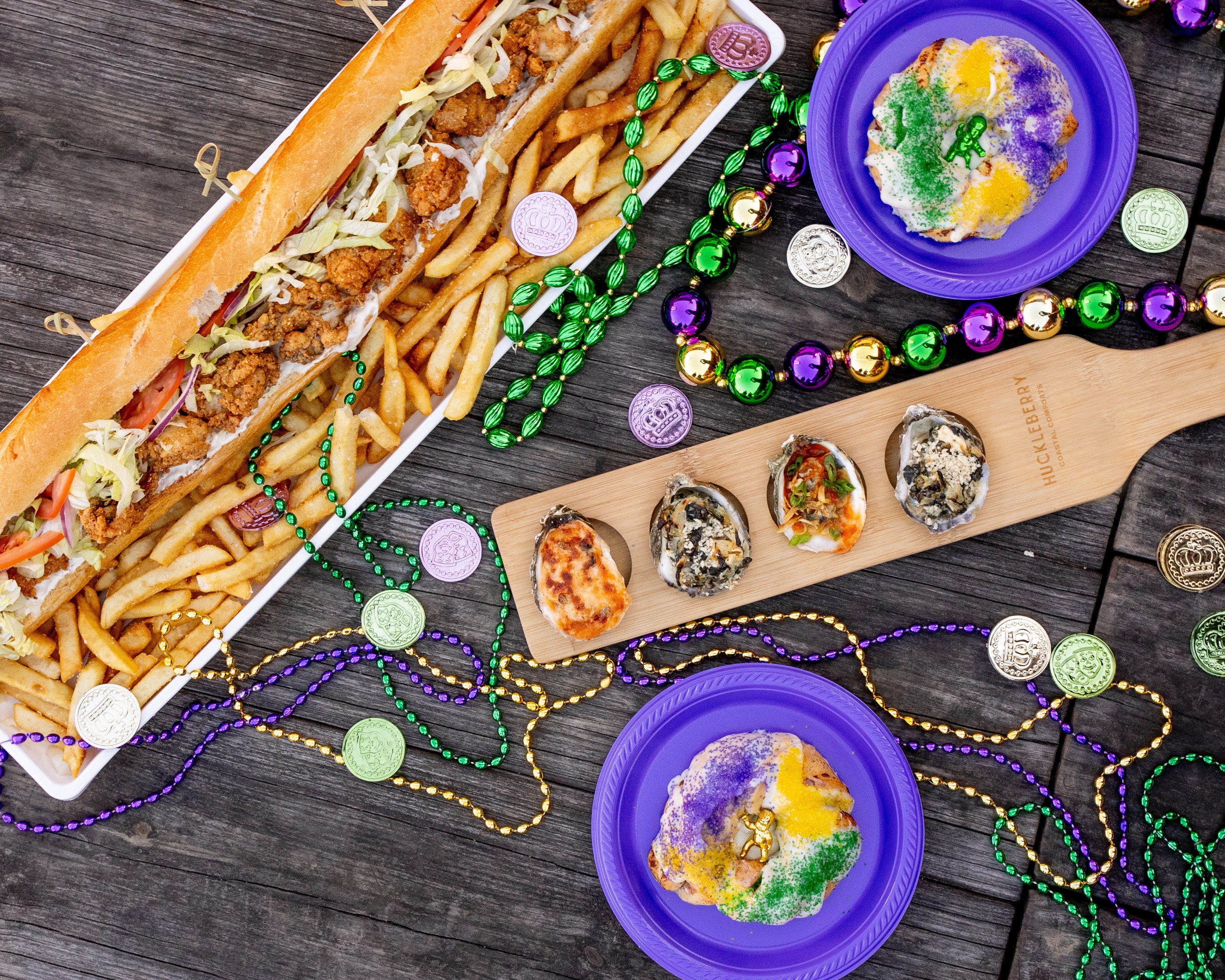 A table of a long sandwich, cakes, and beads.