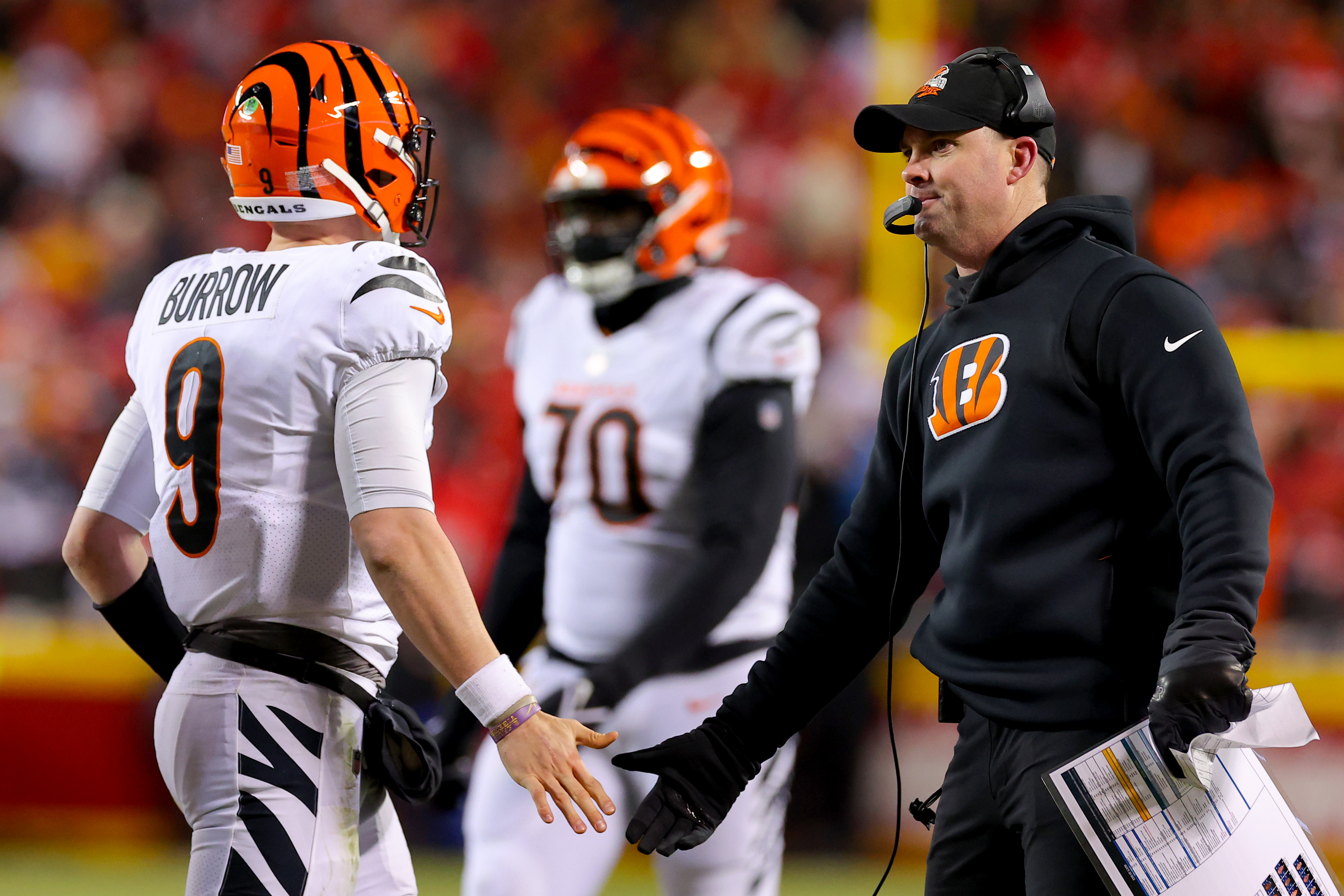 Joe Burrow #9 and head coach Zac Taylor of the Cincinnati Bengals celebrate after a touchdown against the Kansas City Chiefs during the fourth quarter in the AFC Championship Game at GEHA Field at Arrowhead Stadium on January 29, 2023 in Kansas City, Missouri.