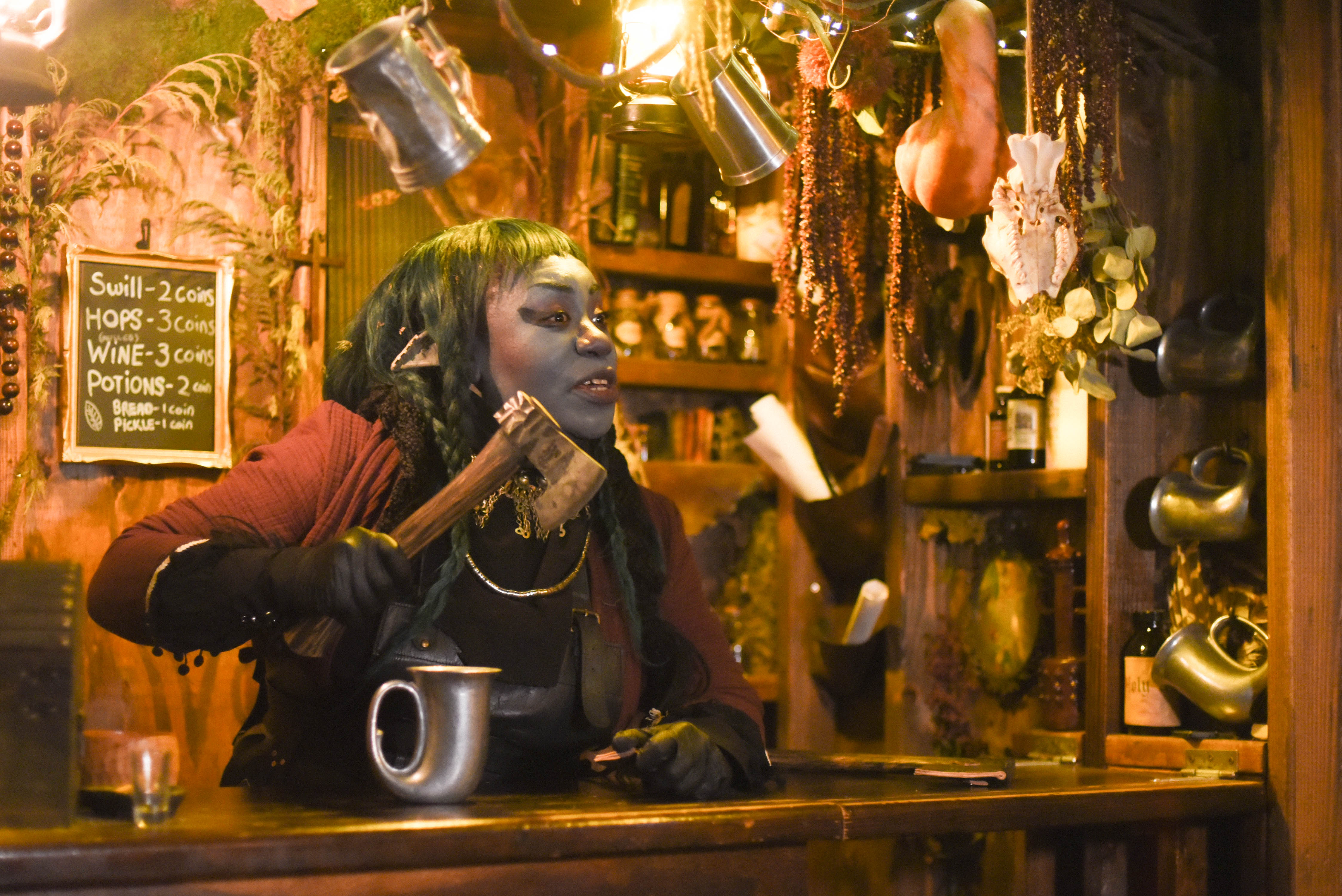 A person in a woodland creature costume behind a bar. 