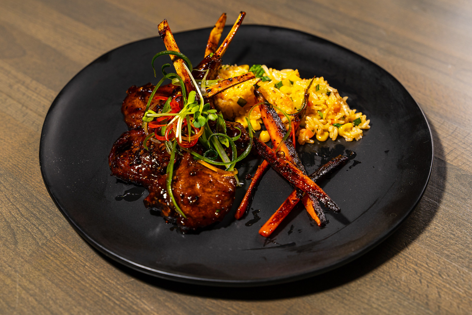 Lamb shops with charred carrots and tamarind rice on a plate.