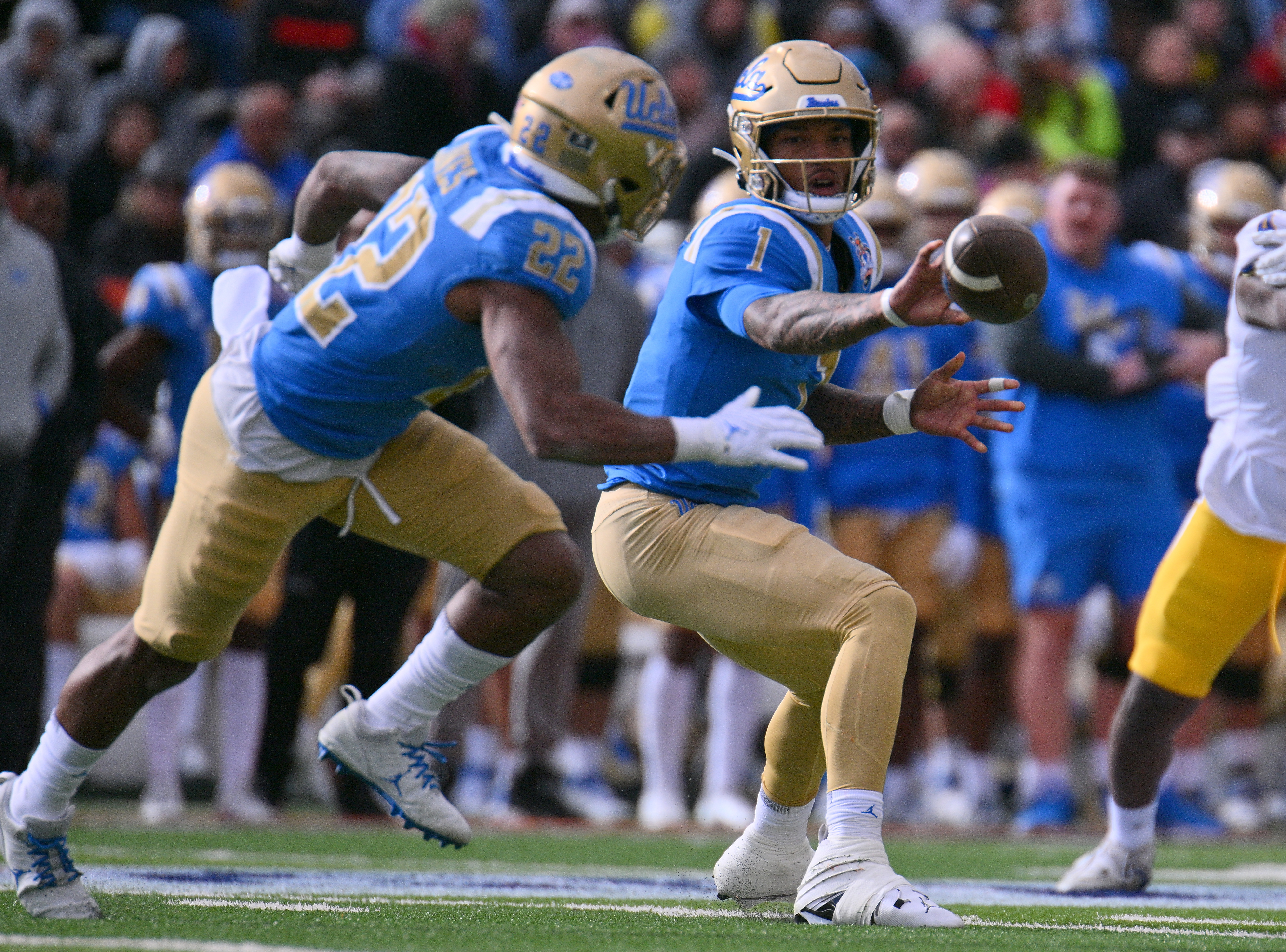 Quarterback Dorian Thompson-Robinson #1 of the UCLA Bruins pitches the ball to running back Keegan Jones #22 during the second half of the Tony the Tiger Sun Bowl game between the Pittsburgh Panthers and the Bruins at Sun Bowl Stadium on December 30, 2022 in El Paso, Texas. The Panthers defeated the Bruins 37-35.