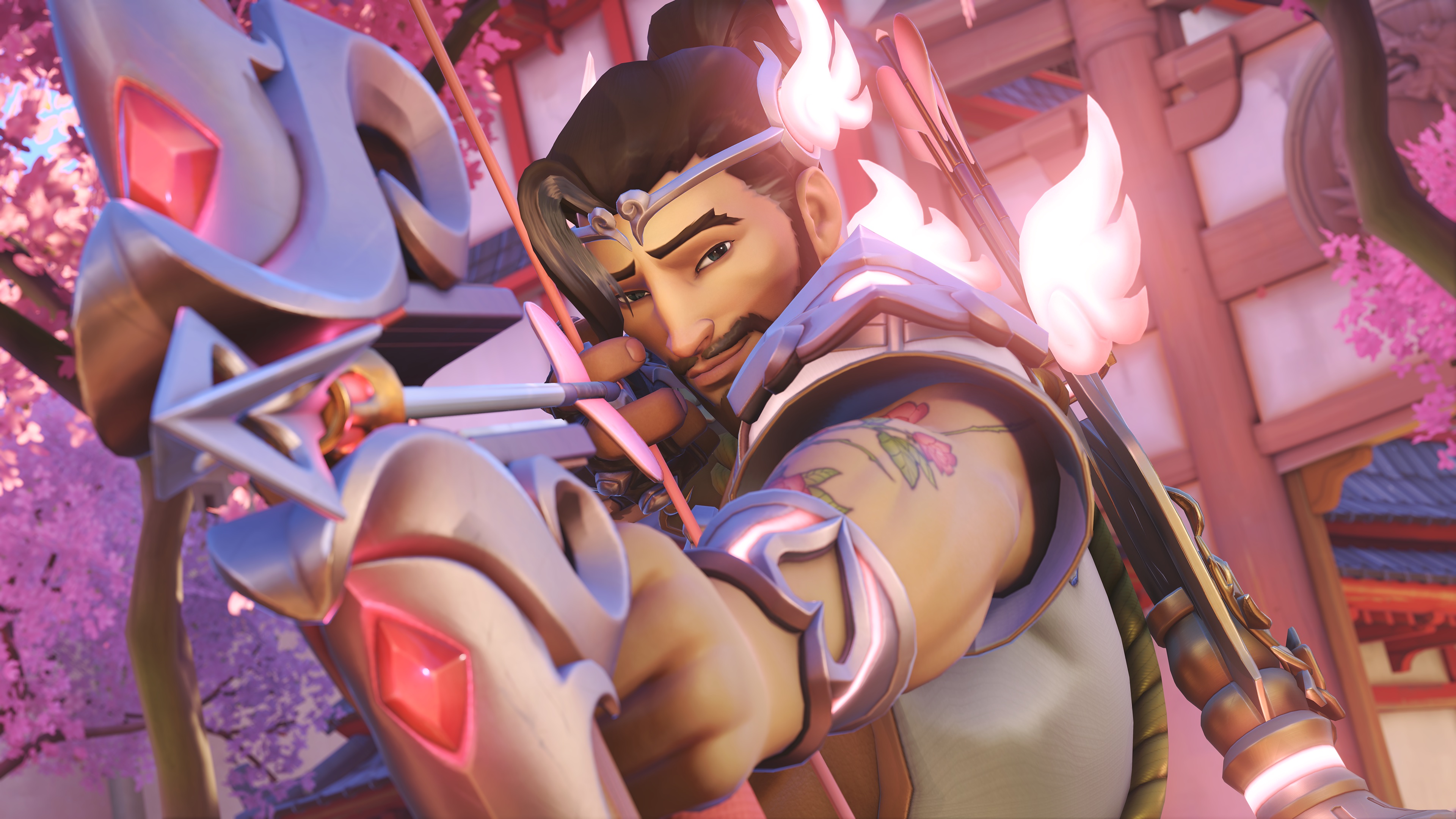 Overwatch hero Hanzo aims his bow and smirks at the camera, while wearing a Cupid-inspired skin.
