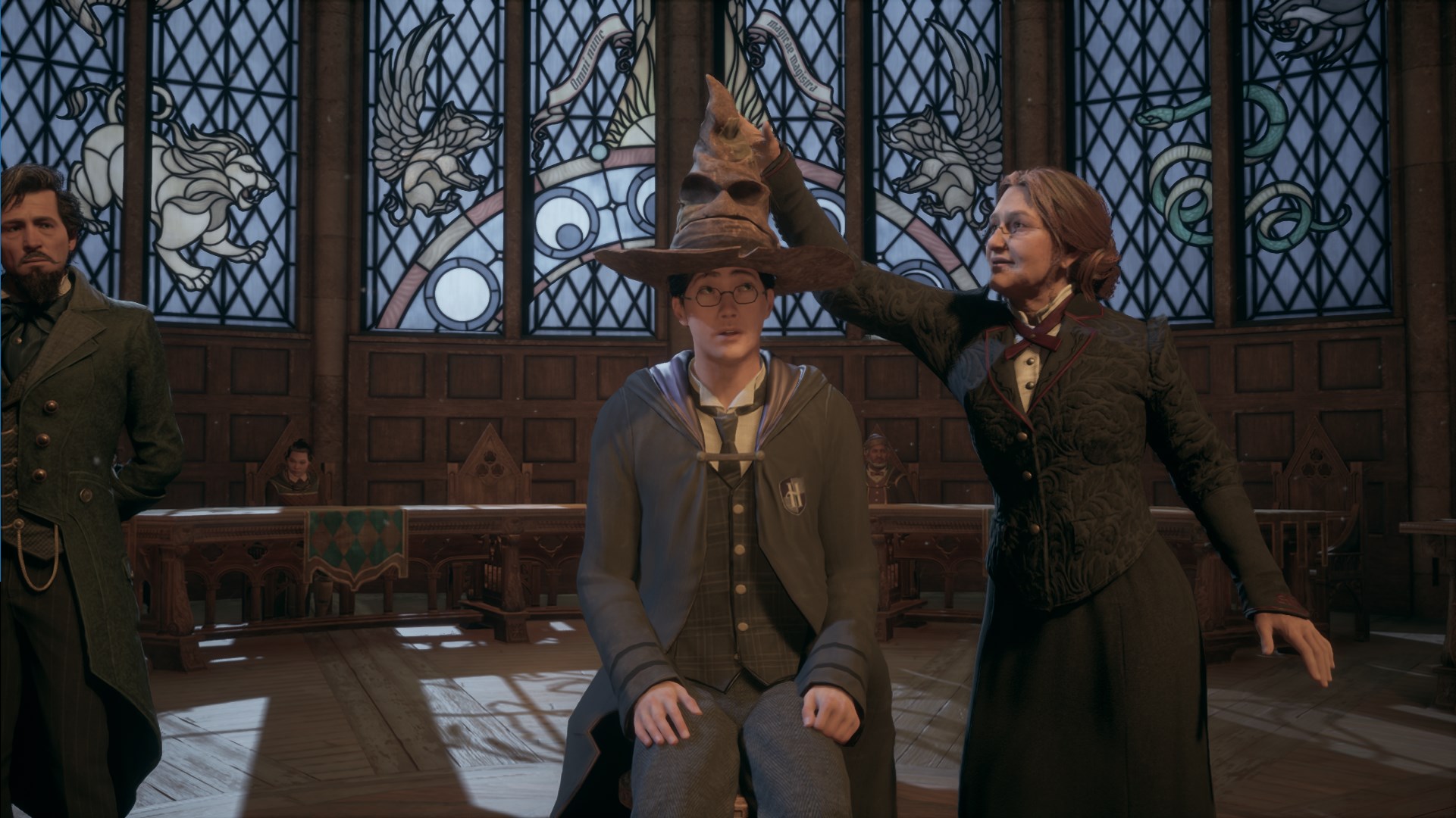 Student sitting in front of stained glass windows with a lady placing a mean looking hat atop their head in Hogwarts Legacy
