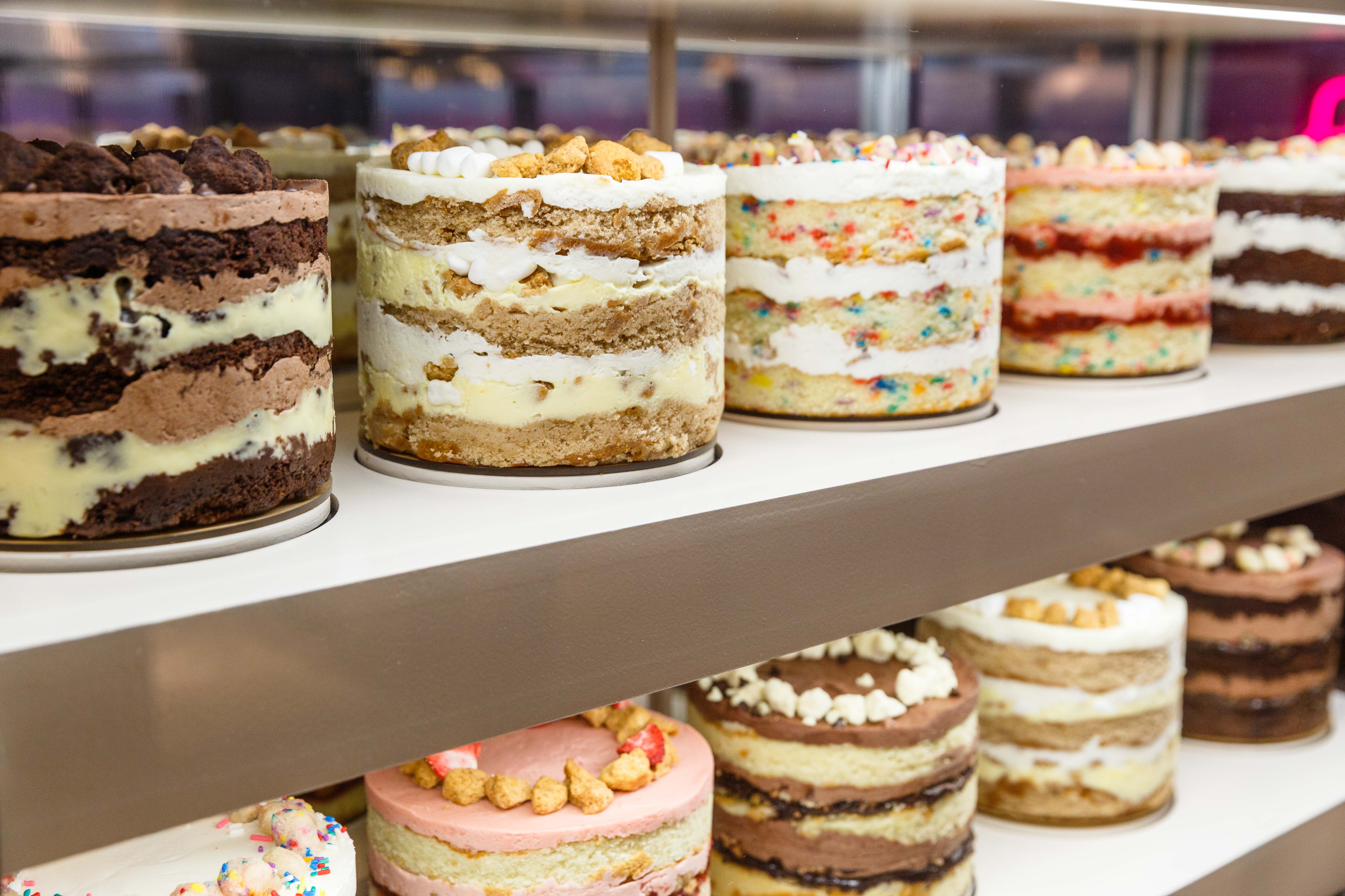 Two shelves are lined with exposed cakes from Milk Bar.