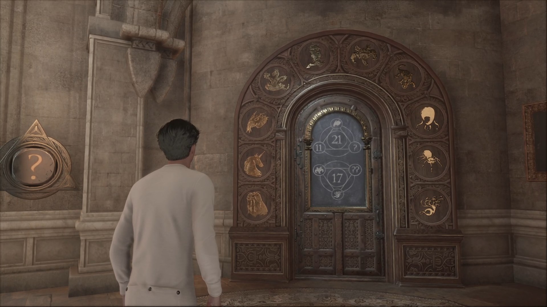Door with triangles and numbers on its face in Hogwarts Legacy. The door is also surrounded in gold images of magical beasts.