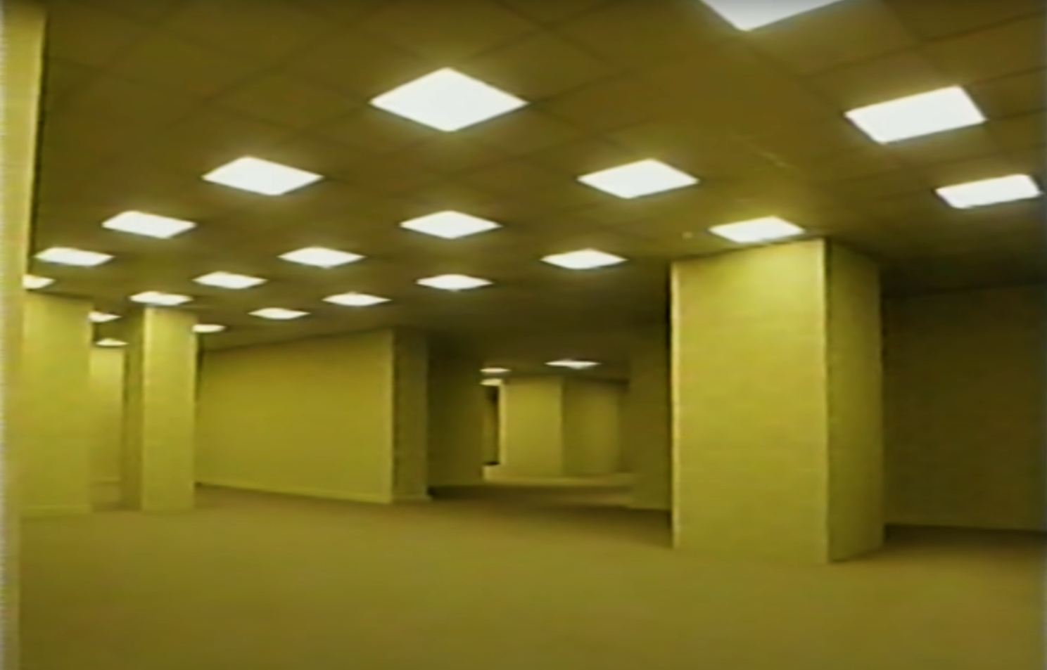 A series of overhead lights in an empty office building hallway