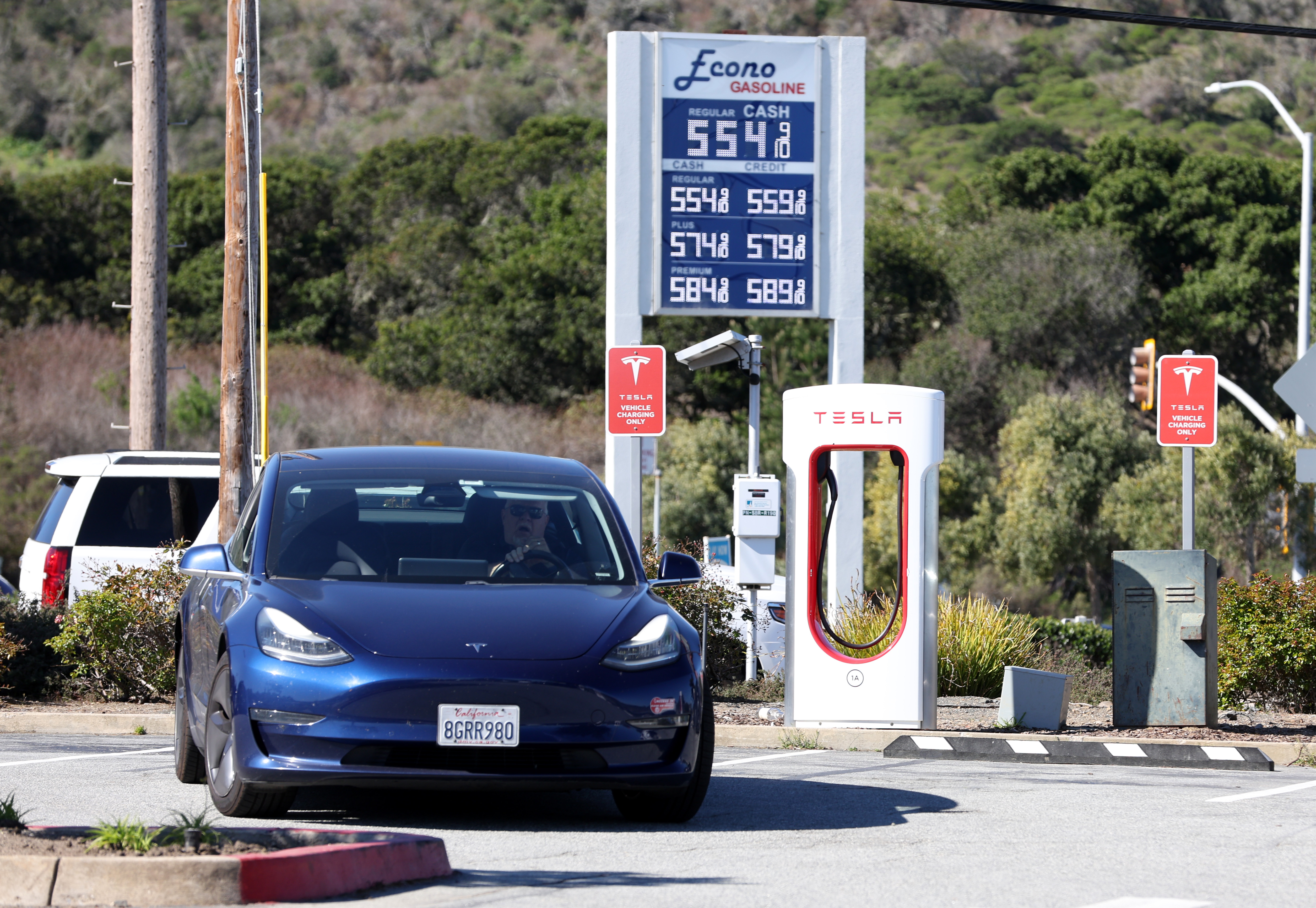 A Tesla car leaves a Supercharger station after recharging its battery on March 10, 2022, in San Bruno, California.