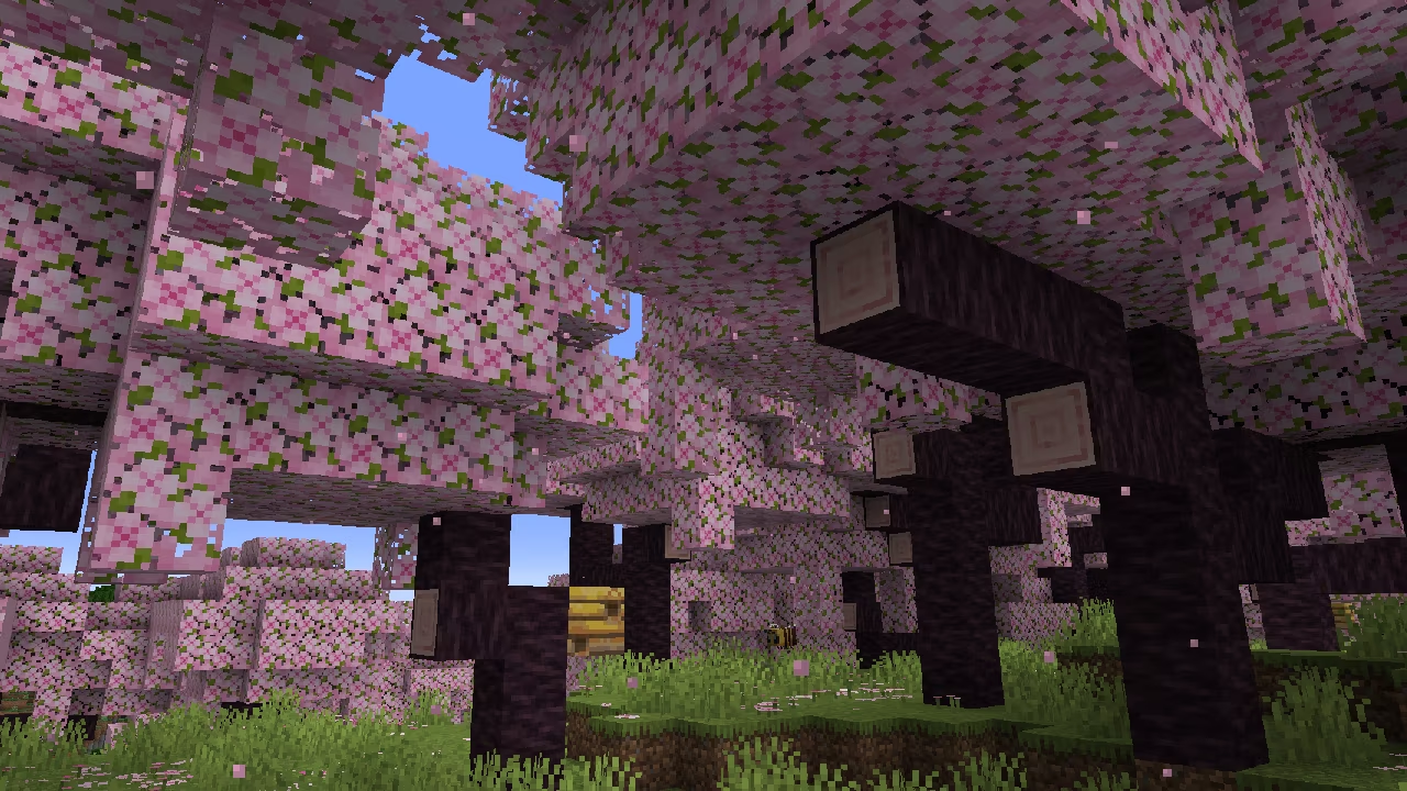 Minecraft - A shot of the new cherry blossom biome, which shows bees buzzing beneath lush pink leaves in a lovely forest.